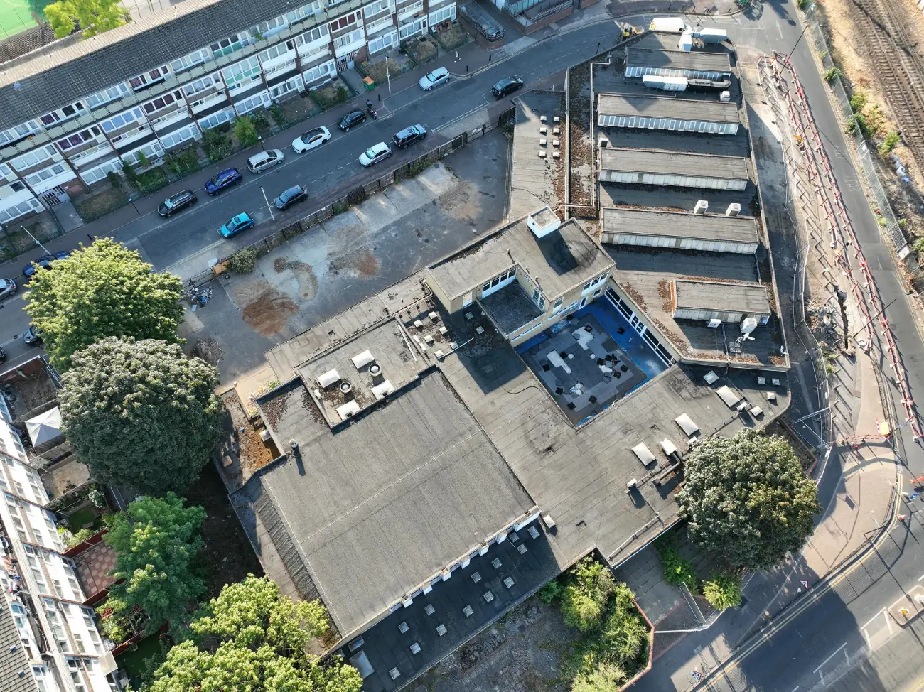 Top-down aerial view of a flat roof complex taken during a roof inspection to assess surface condition.