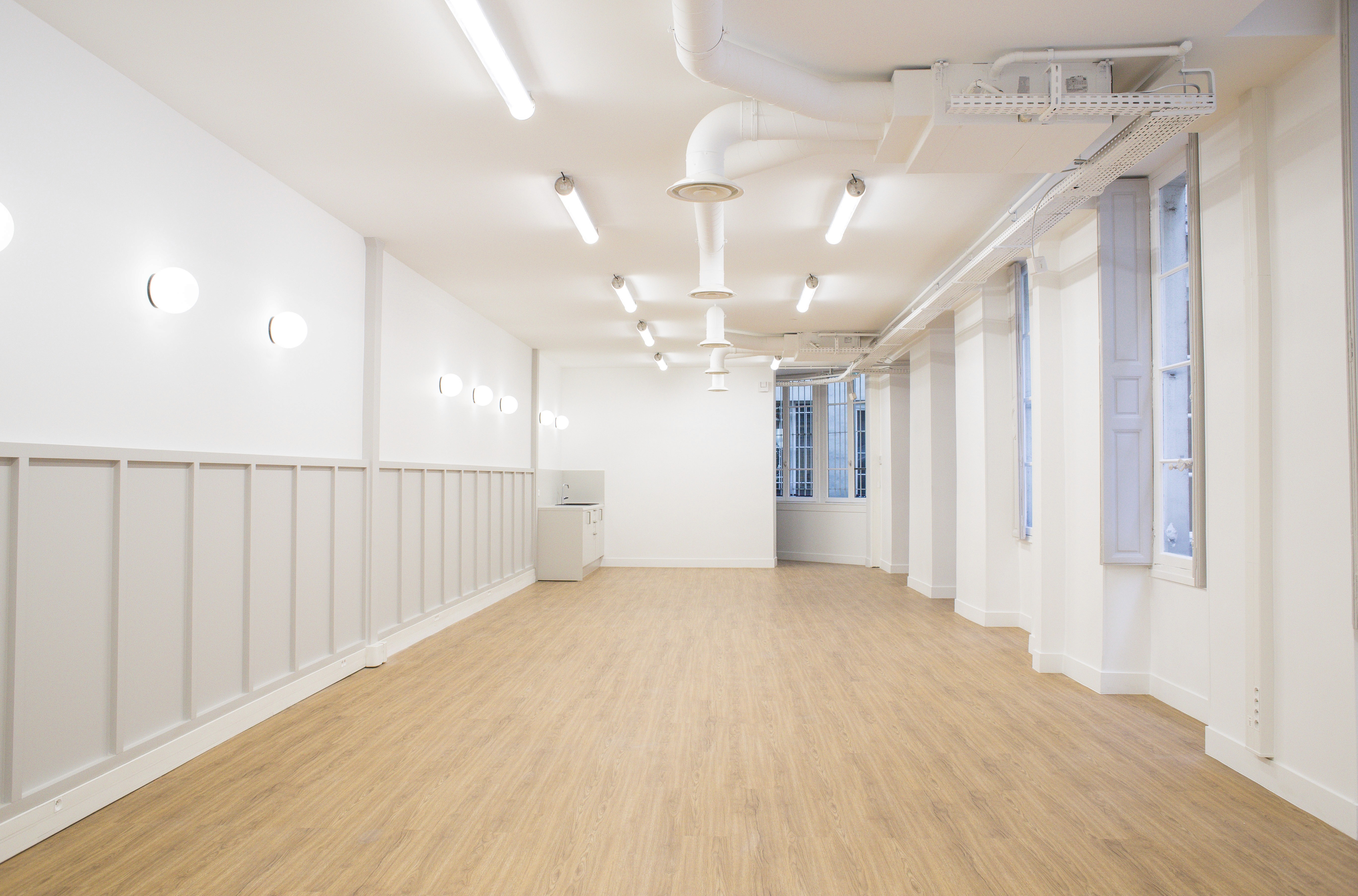 Espace showroom lumineux de l'agence Clothette, avec parquet clair et murs blancs minimalistes