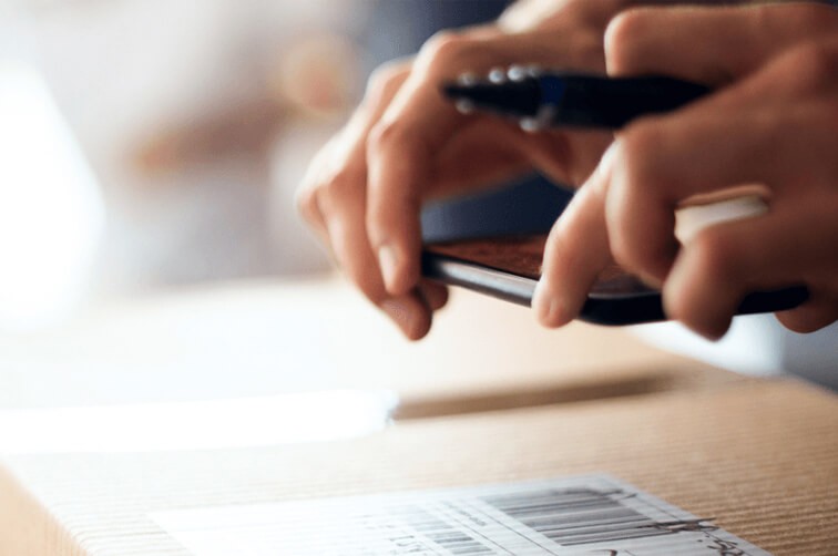 Person scanning parcel barcode with smartphone