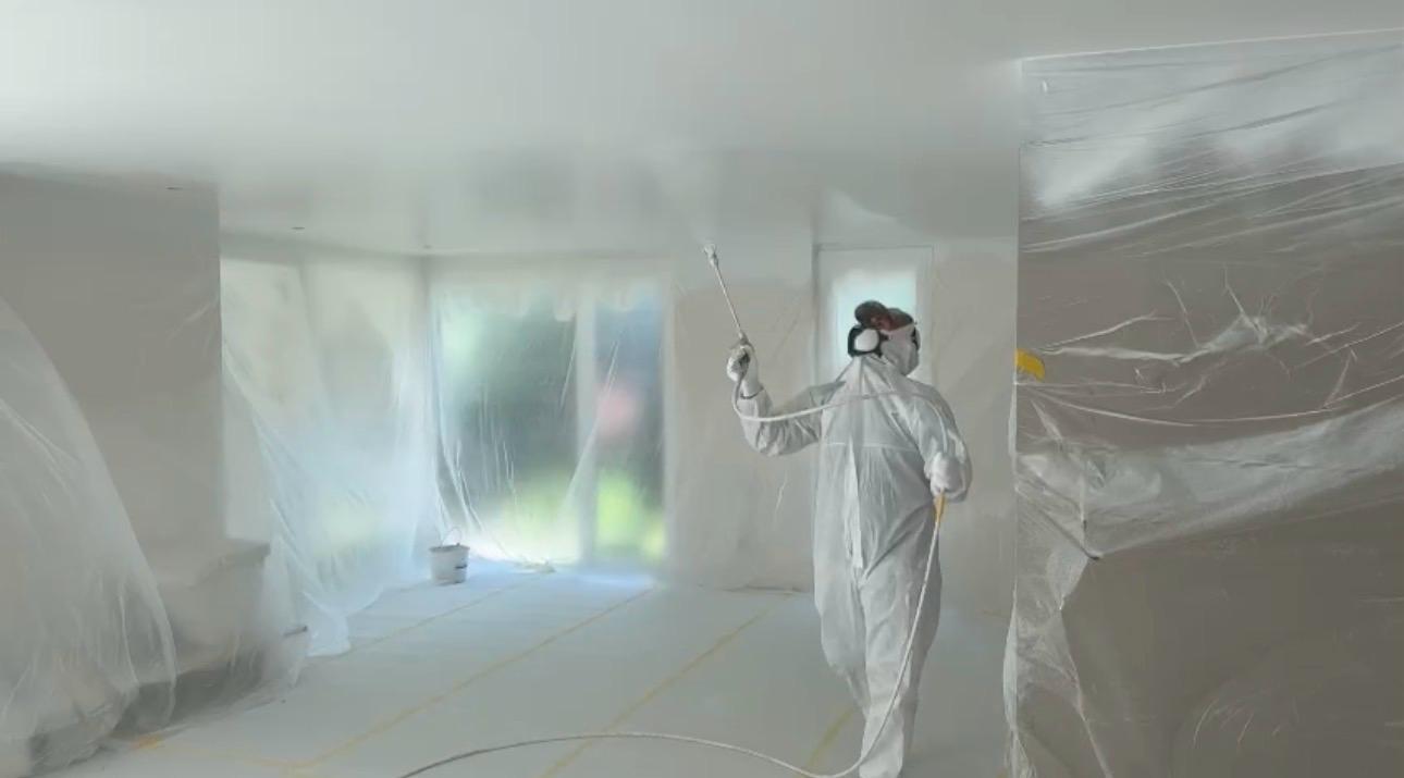 Garrido's vakman voert spuitwerk uit in beschermend pak - professioneel schilderwerk interieur