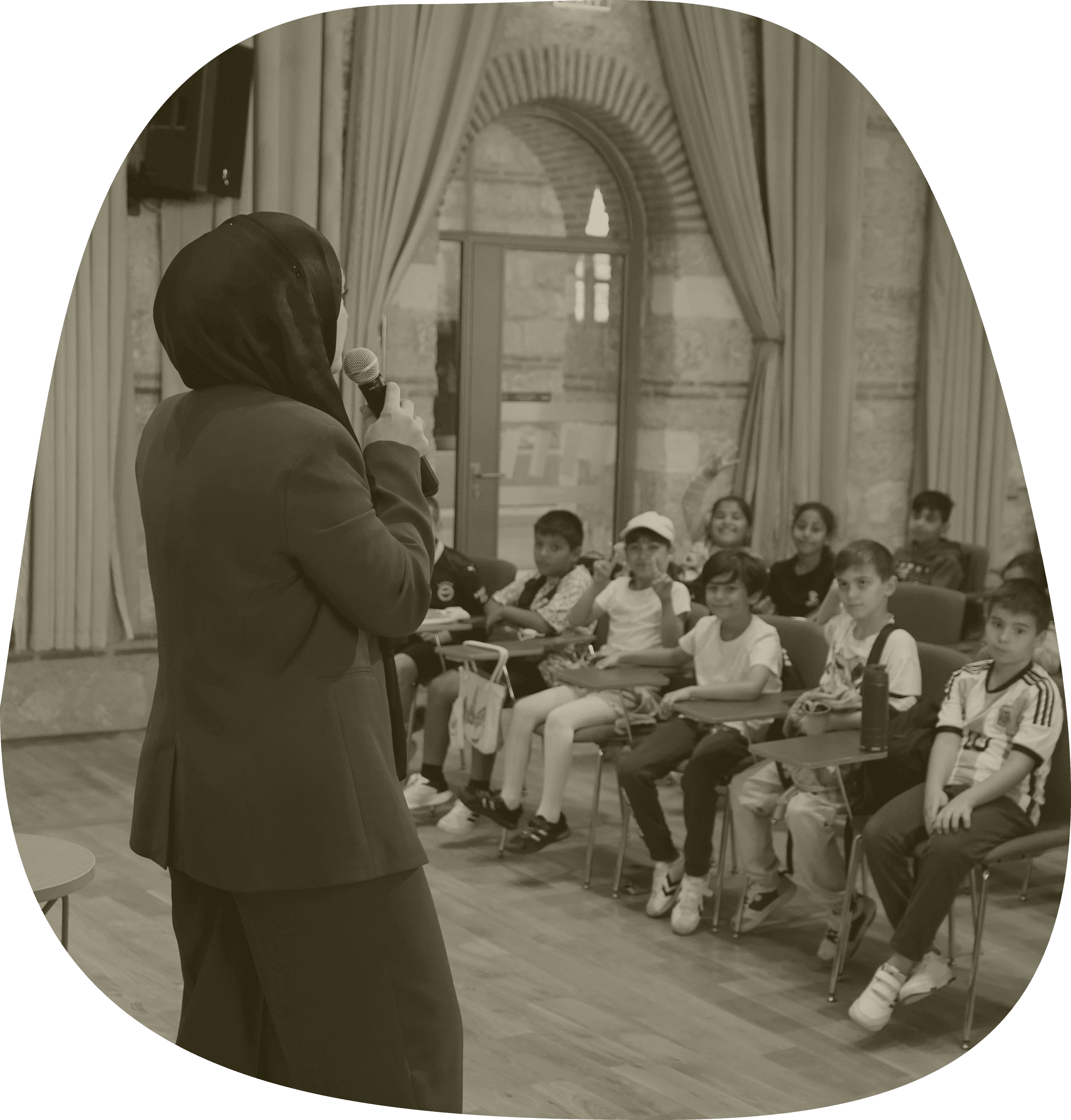 Bir konuşmacı, bir grup çocuğa konuşma yapıyor.