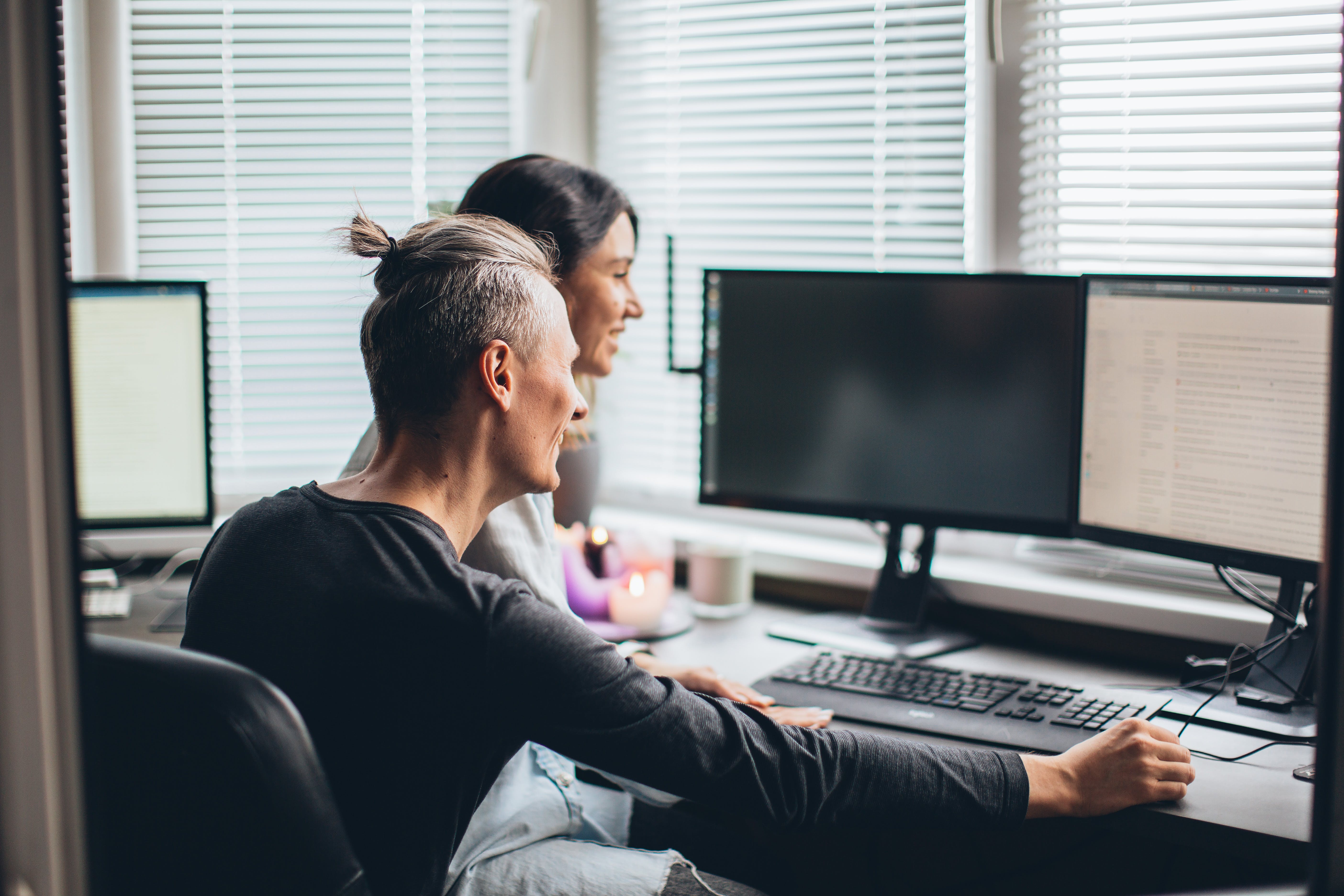 Couple mastering cold email sales in front of computer for their business