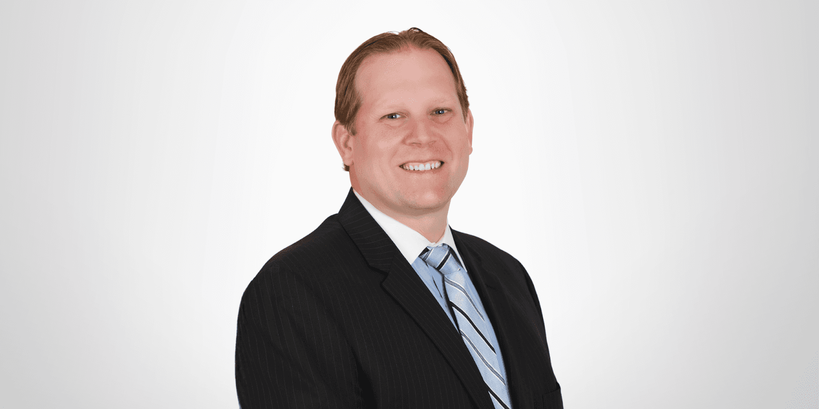 Christopher A. Herring, a financial advisor from Herring Wealth Management, smiling in a professional suit with a blue tie.