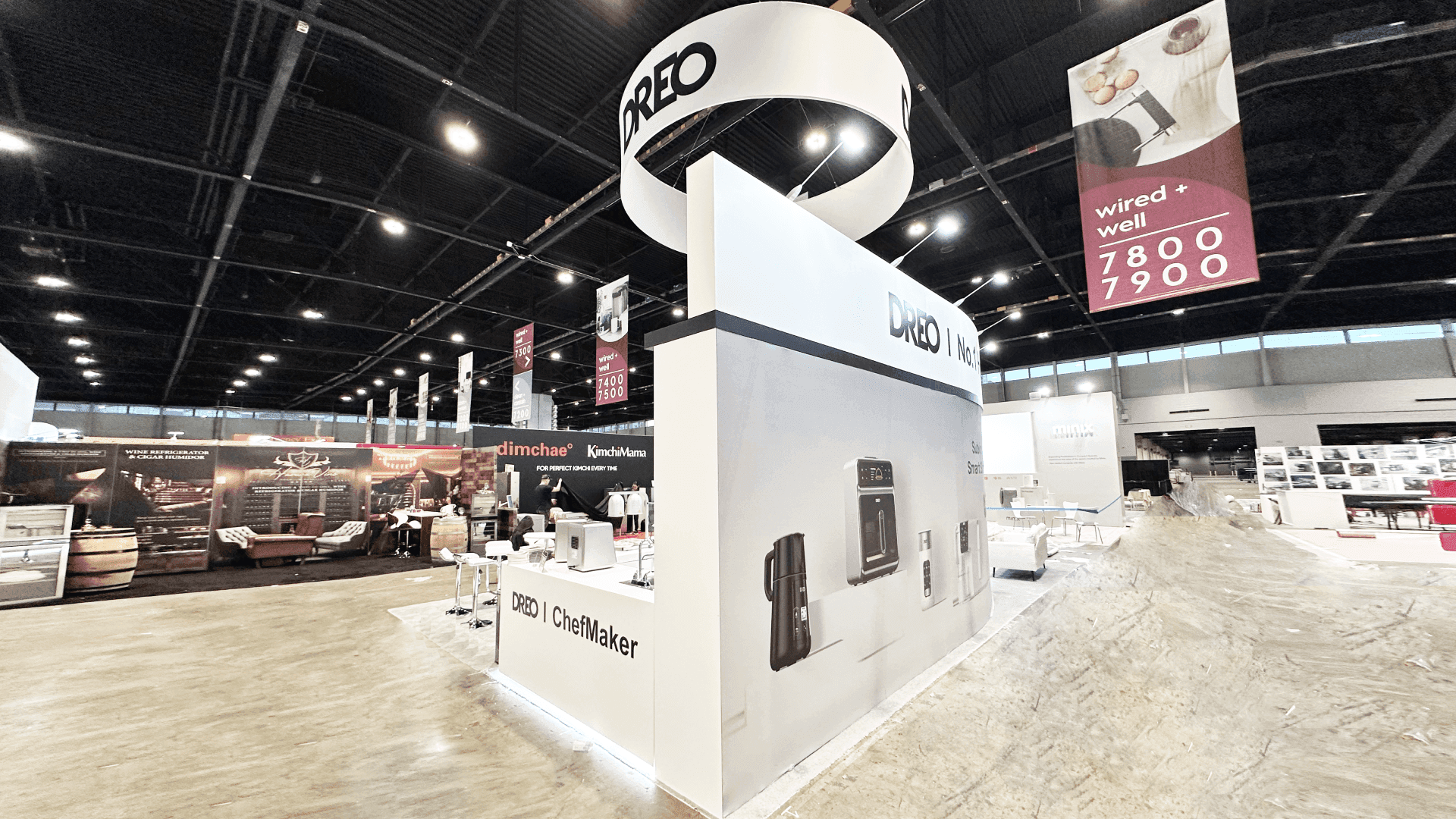 DREO IHS 2025 20x30 retail product display booth side brand wall view with large appliance graphics, circular hanging sign, clean white structure, and open aisle-facing presentation design.