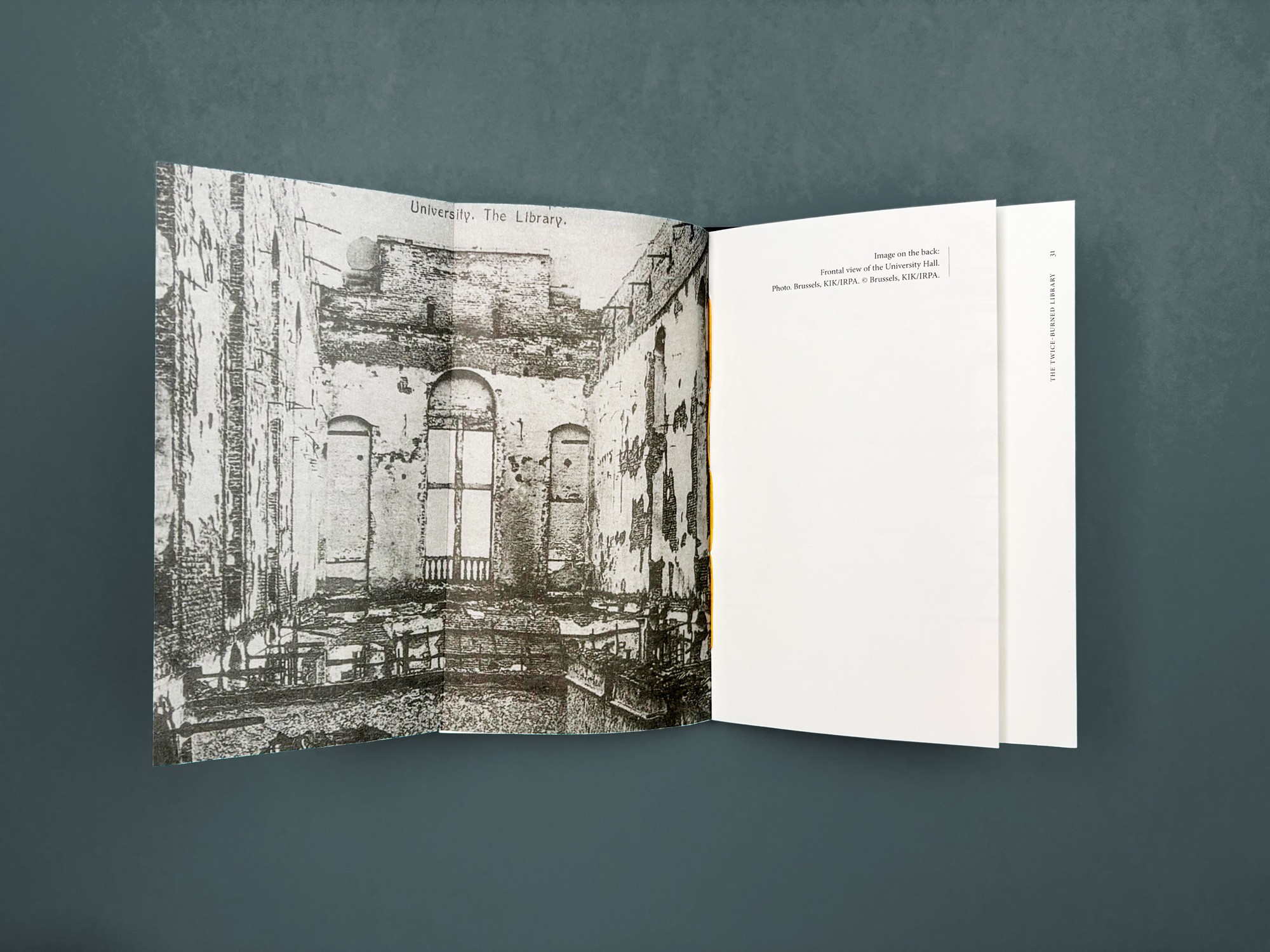 Een bovenaanzicht van een opengeslagen boek op een grijze ondergrond. De linkerpagina toont een korrelige zwart-witfoto van een historisch gebouw met een plein ervoor. De rechterpagina bevat een strakke kolom tekst met brede marges.