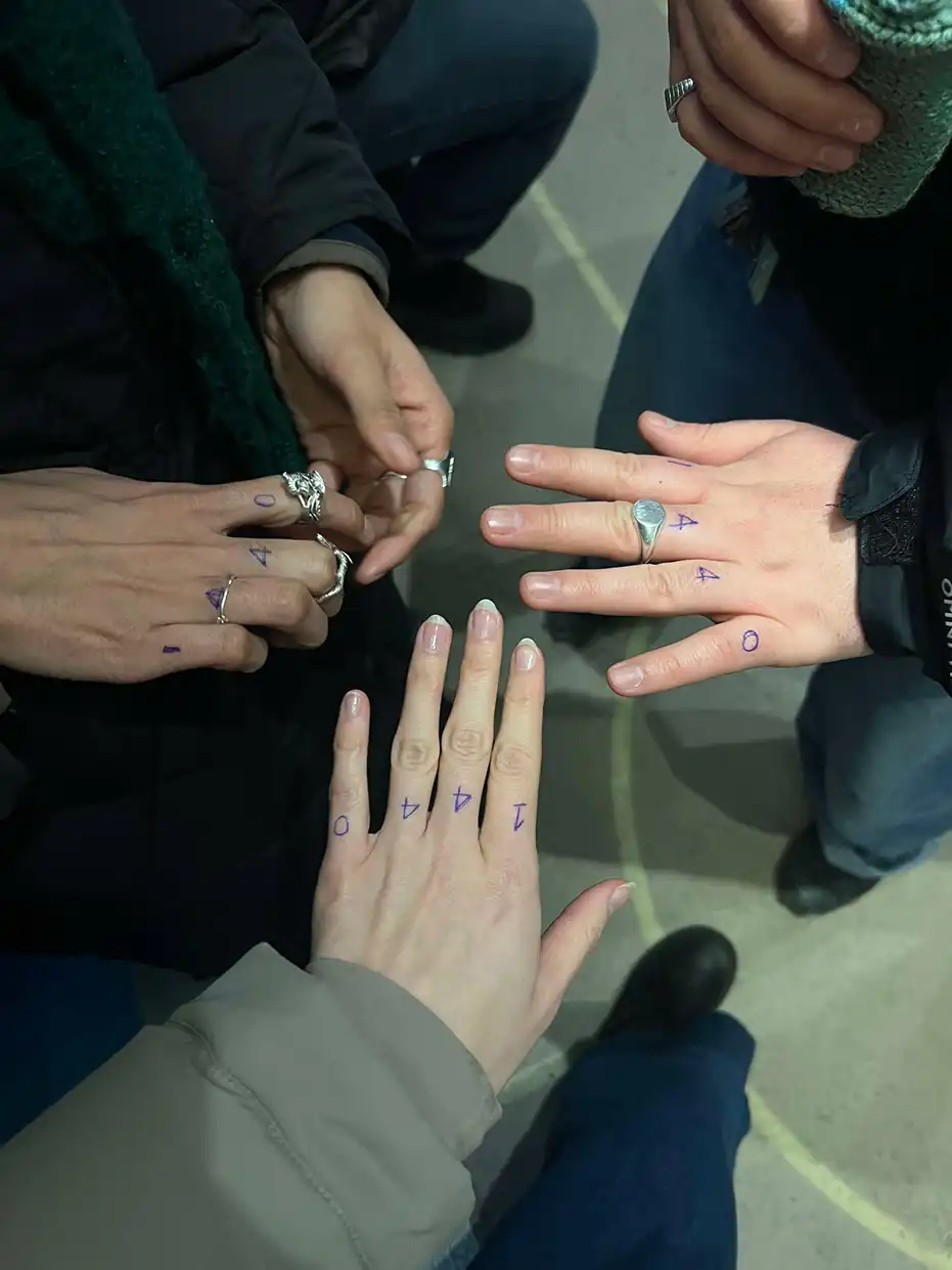 Groupe de mains rapprochées avec les chiffres “1 4 4 0” dessinés au stylo sur les doigts, symbole du Collectif1440.