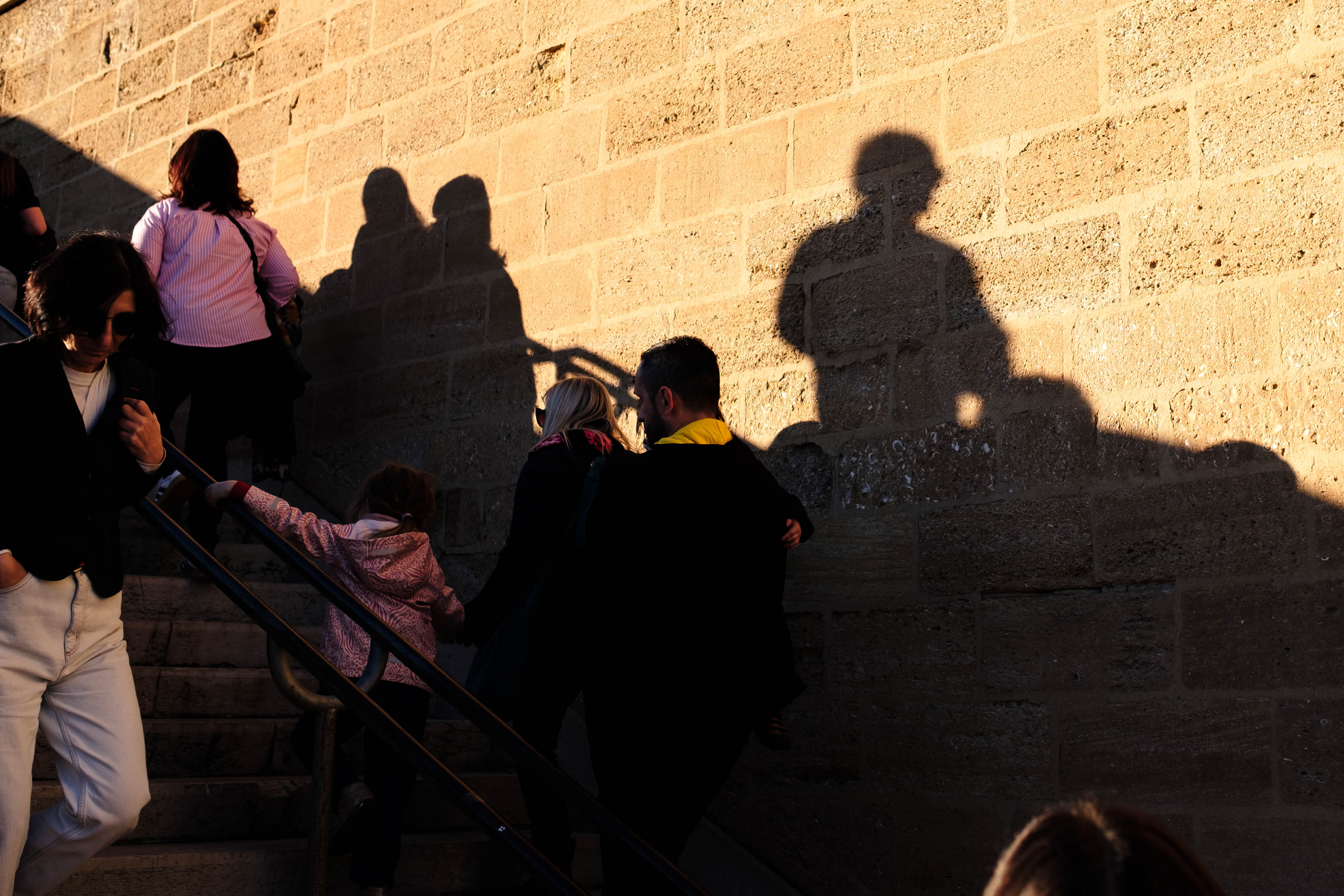 Shadows of people gowing down the stairs