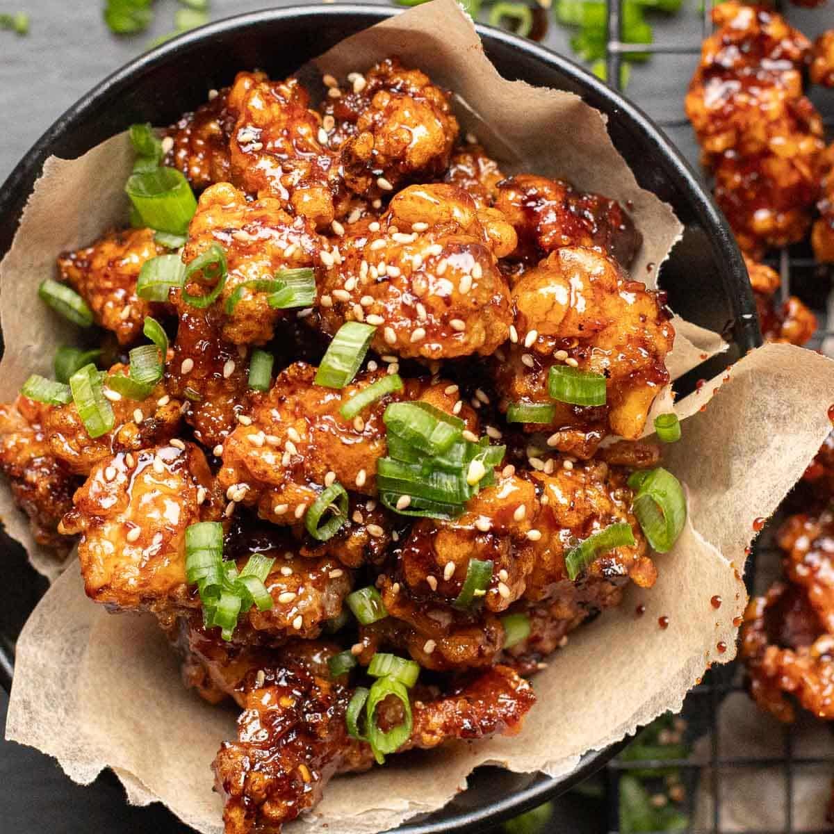 Crunchy fried chicken tossed in bold Korean spices and sweet-spicy Yangnyeom sauce, finished with sesame and fresh veg