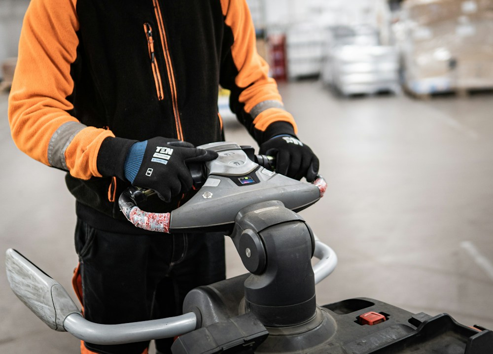 Representative photograph: A warehouse employee operating material-handling equipment.