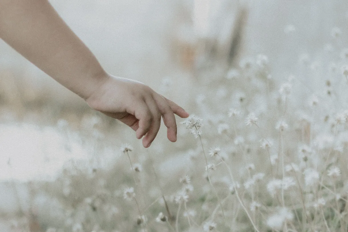 A baby holding a parent’s finger