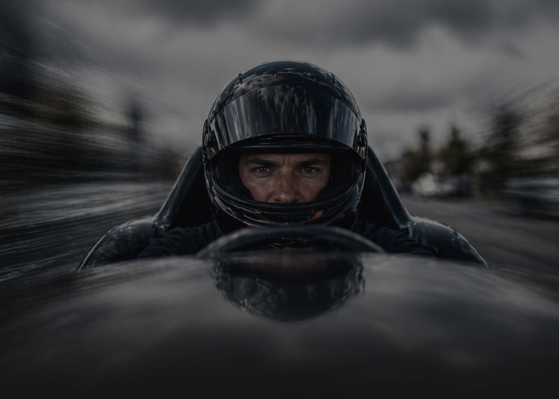 Hands typing on a laptop keyboard on a wooden desk, wearing a brown ribbed sweater