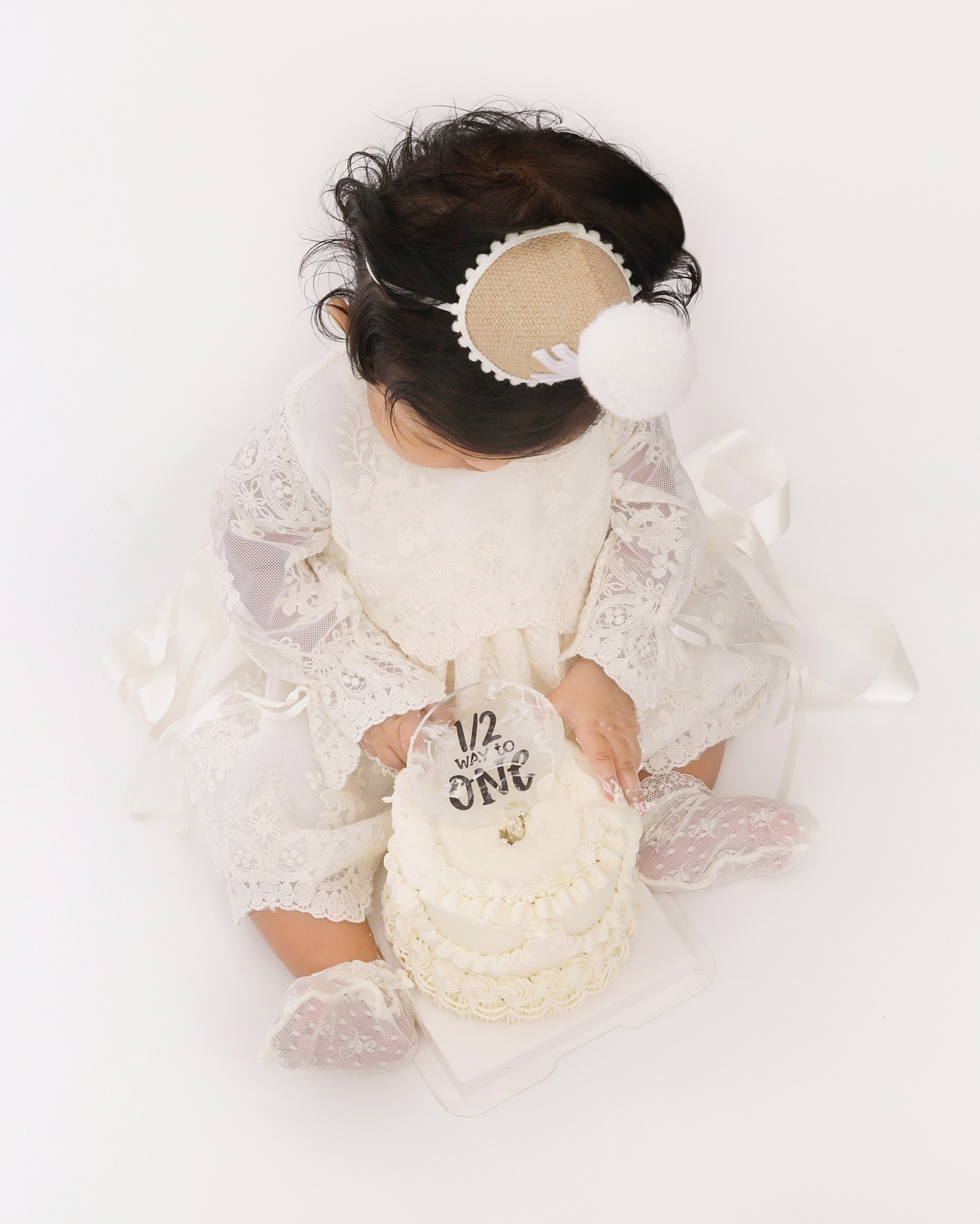 Newborn photoshoot Dubai by Mahvin Photography with a 6-month-old baby having a cake smash session captured in a creative studio.