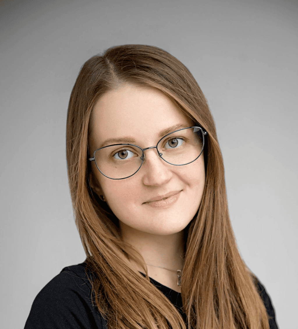 a woman standing next to a white wall