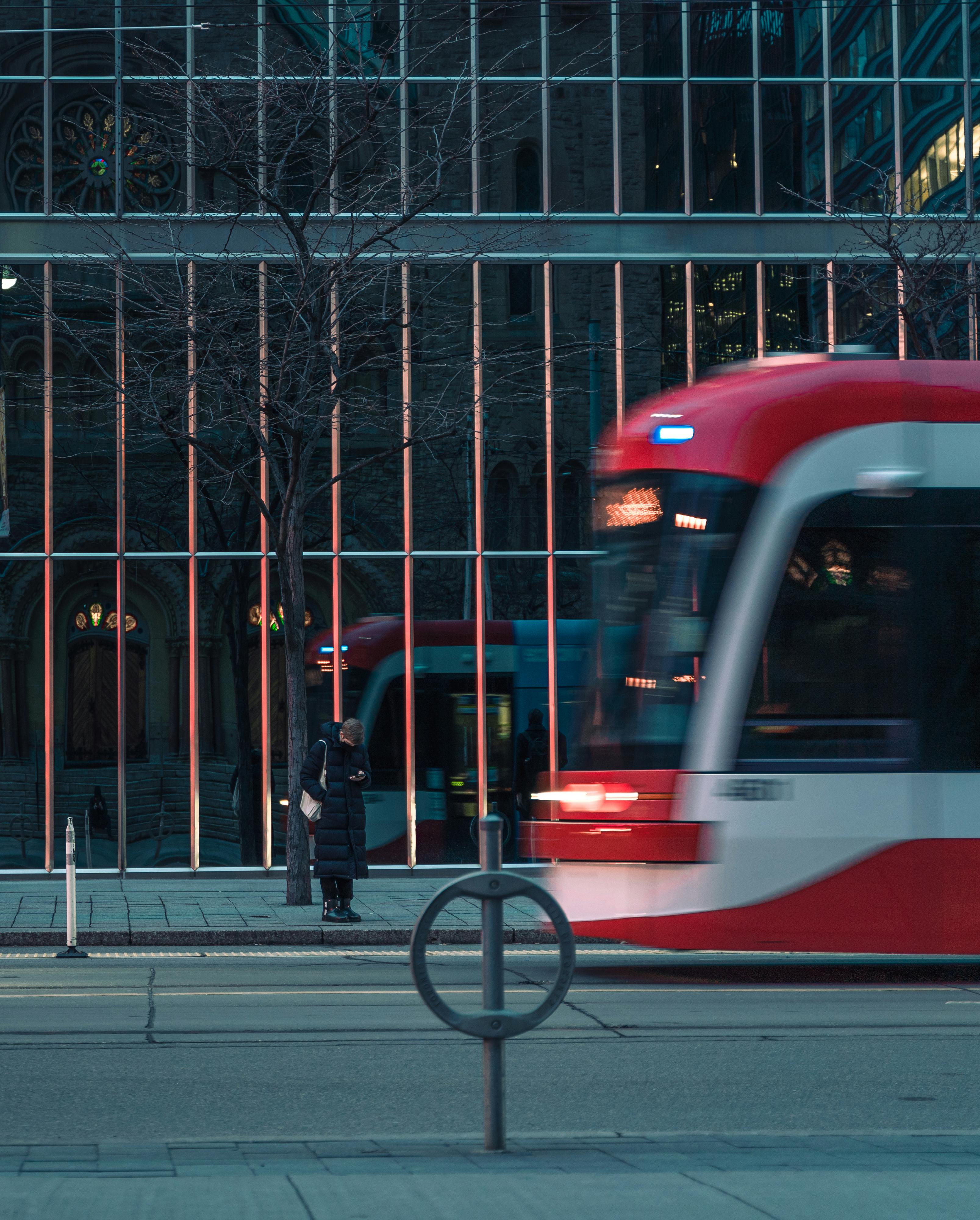 Smiling young man with short hair poses against a dark background, wearing a green button-up shirt.