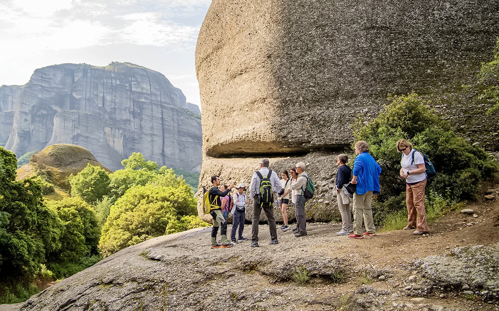 Gasten die wandelen tussen rotsformaties tijdens de Meteora Wandeltour met Bezoek aan het Klooster.
