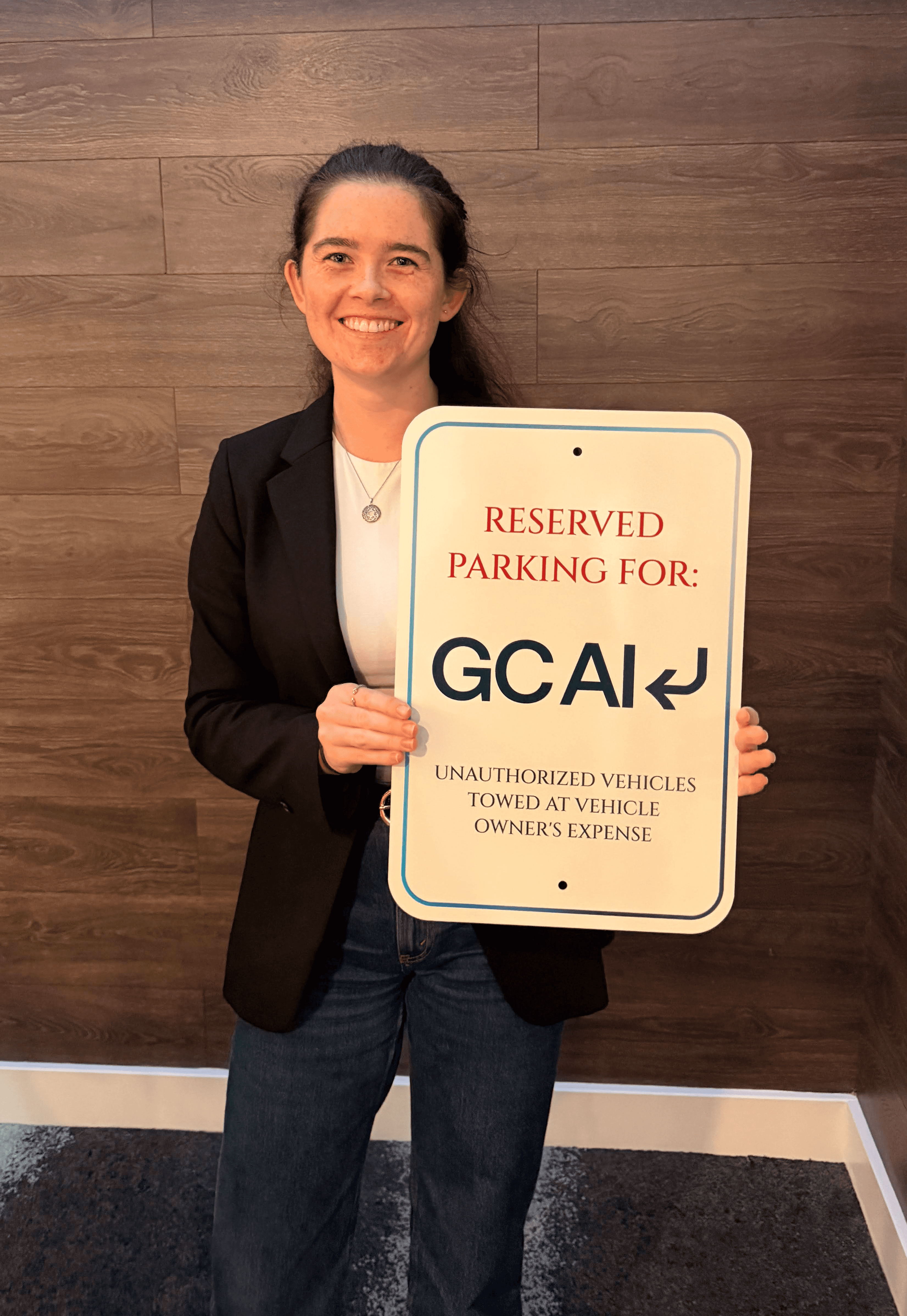 GC AI employee holding a "Parking Reserved for GC AI" sign