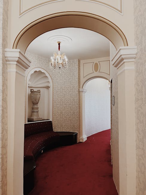 Elegant interior design featuring archways, a chandelier, and a plush red carpet. Captured in Veracruz, Mexico.