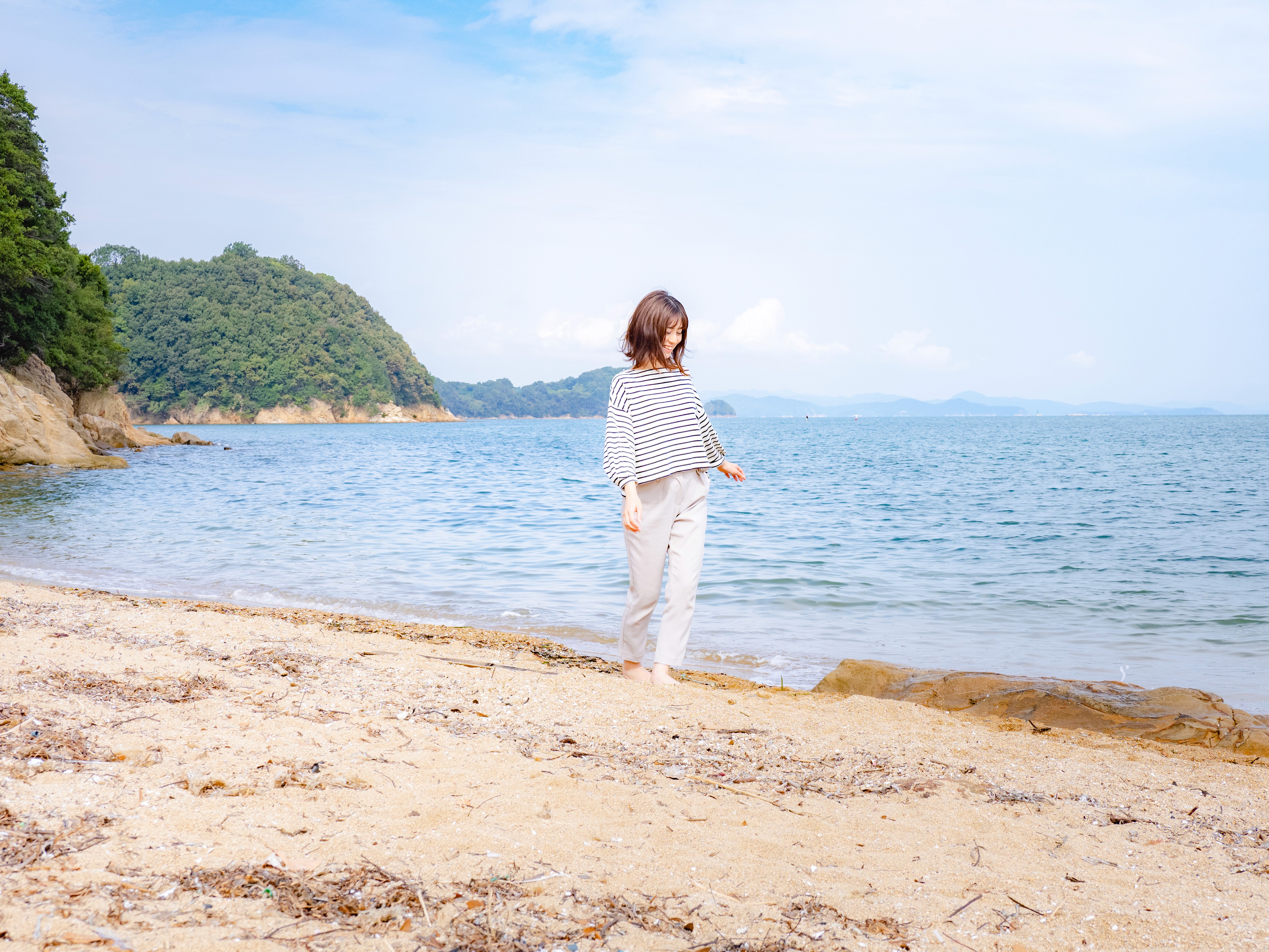A young woman walking along the seashore