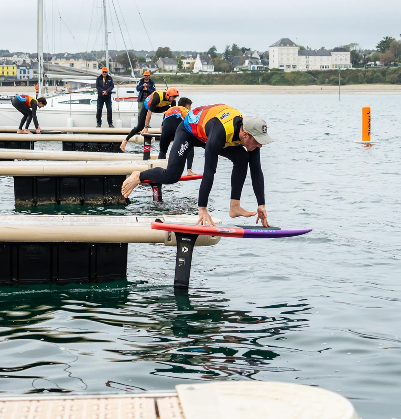 Une personne s'élance d'un ponton pour sauter sur sa planch à foil lors d'une compétition de dockstart