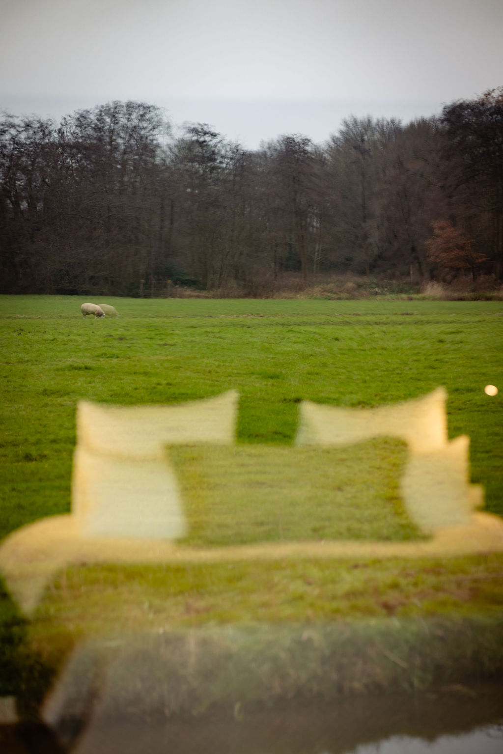 lounge room with large contemporary lamp, cozy sofa and blue toned painting of Venice