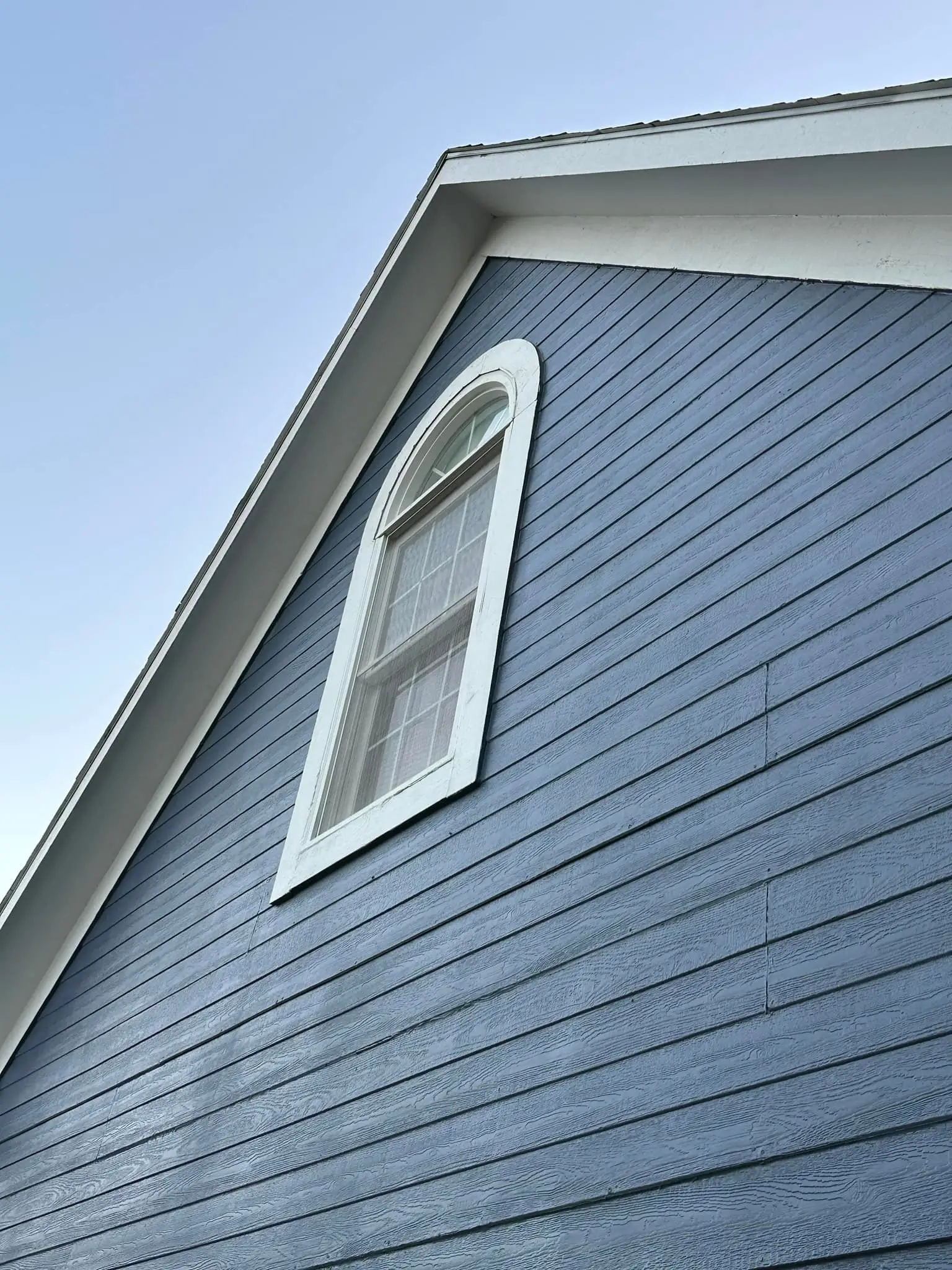 An image showing the siding and trim of a blue house with white trim.