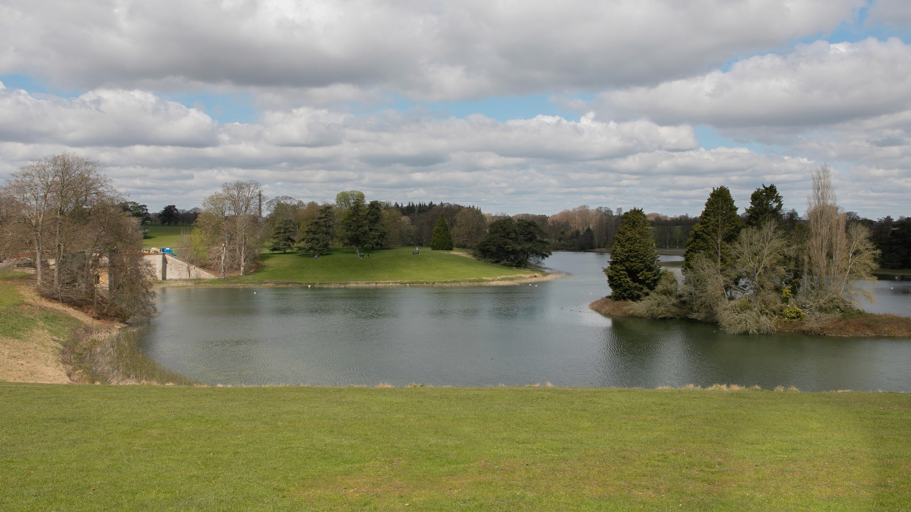 Two classic volkswagen beetles, one green, one cream.