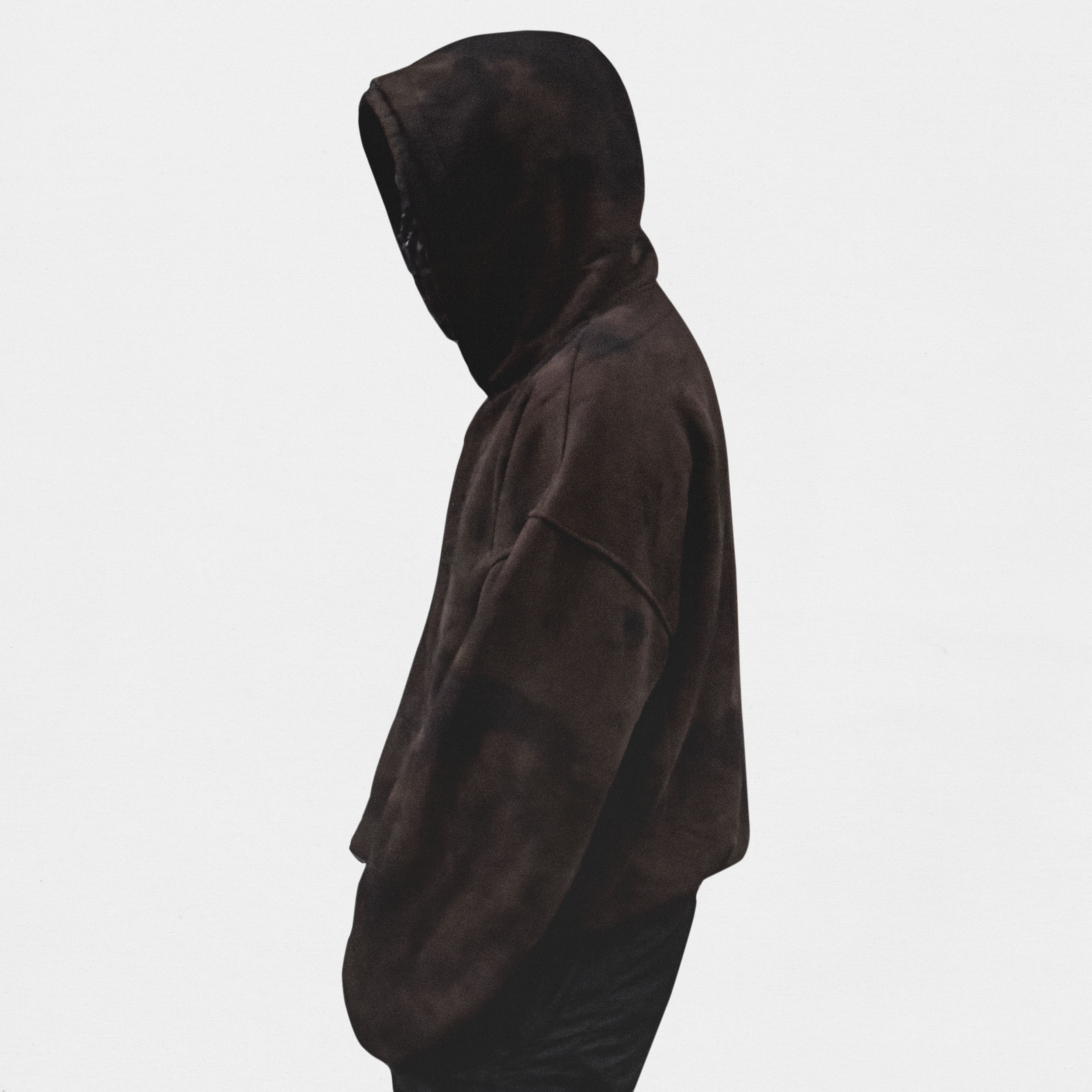 Model wearing brown hoodie on white background, portrait