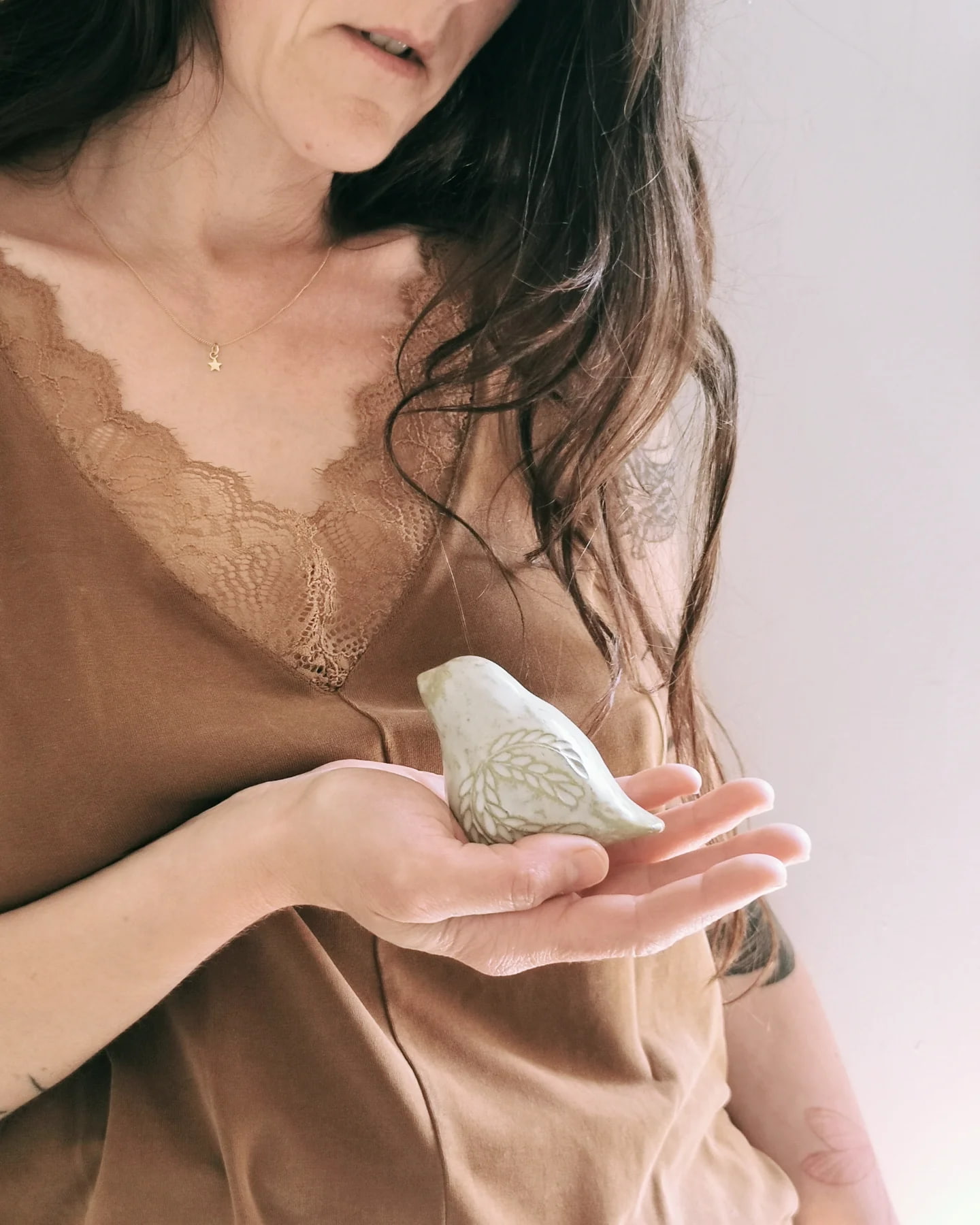 Céramiste de Guérande tenant un oiseau en grès émaillé vert gravé, pièce unique artisanale