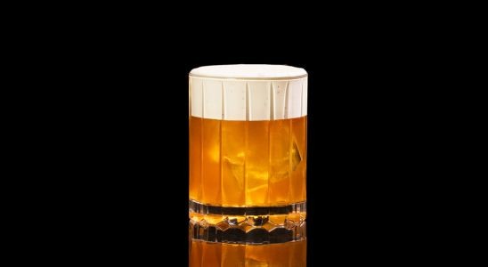 A closeup of a Savory, Winter Afternoon Tea Old Fashioned drink against a dark background.