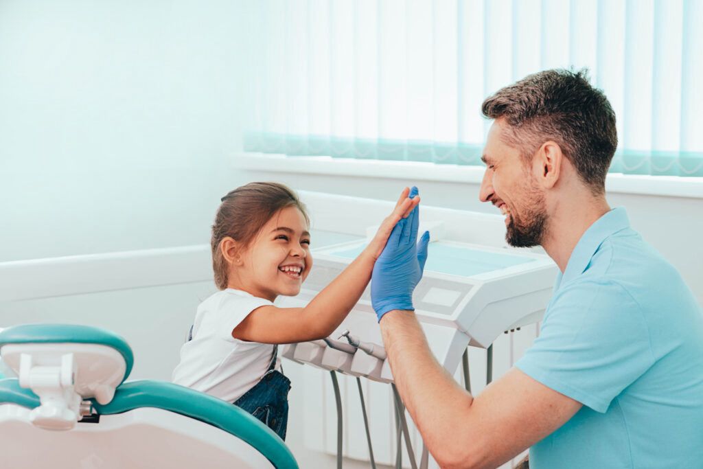 dentist holding syringe into boy's mouth
