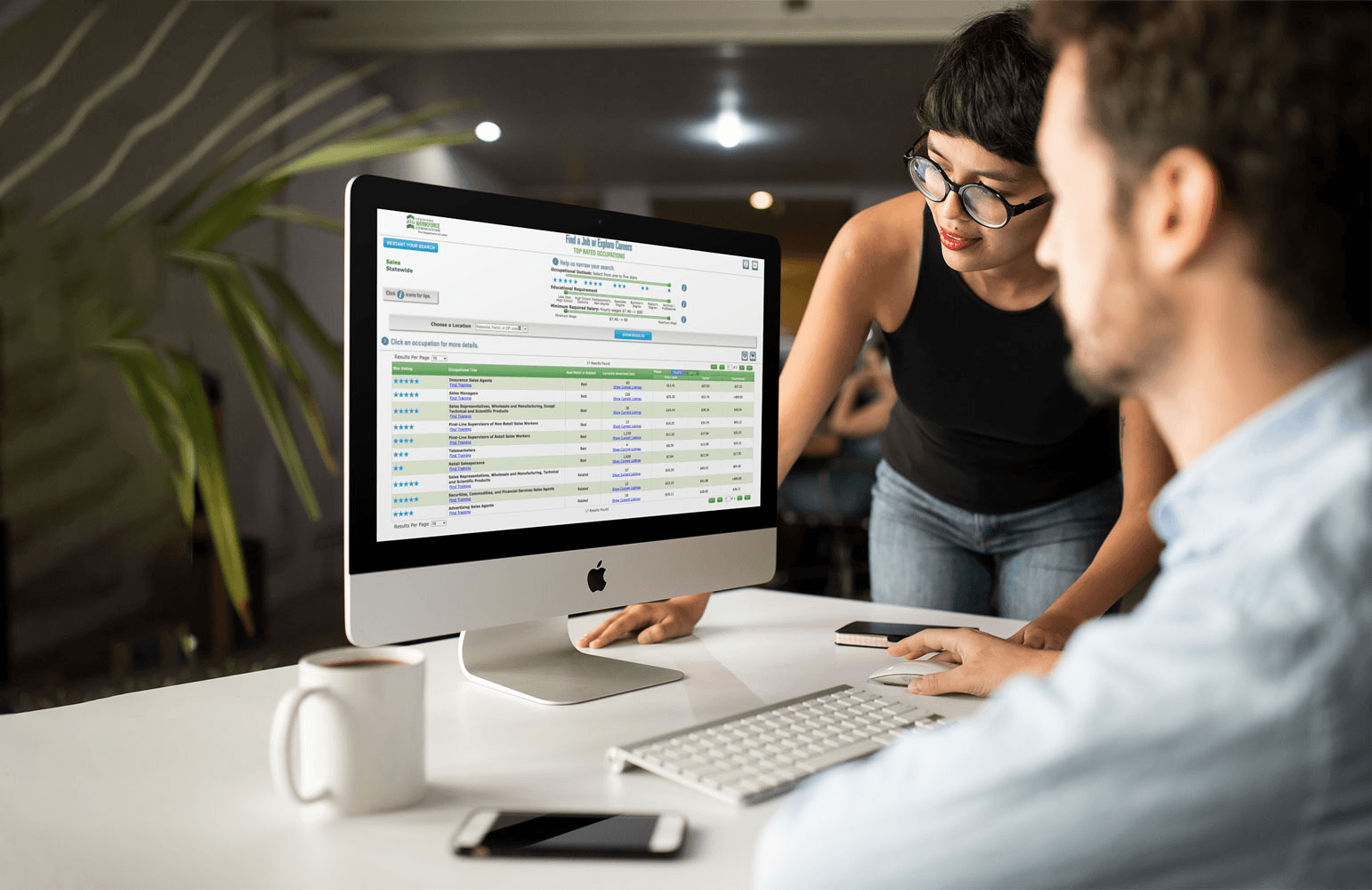 Two people looking at computer screen - How to Create a Google Sheets Budget Template