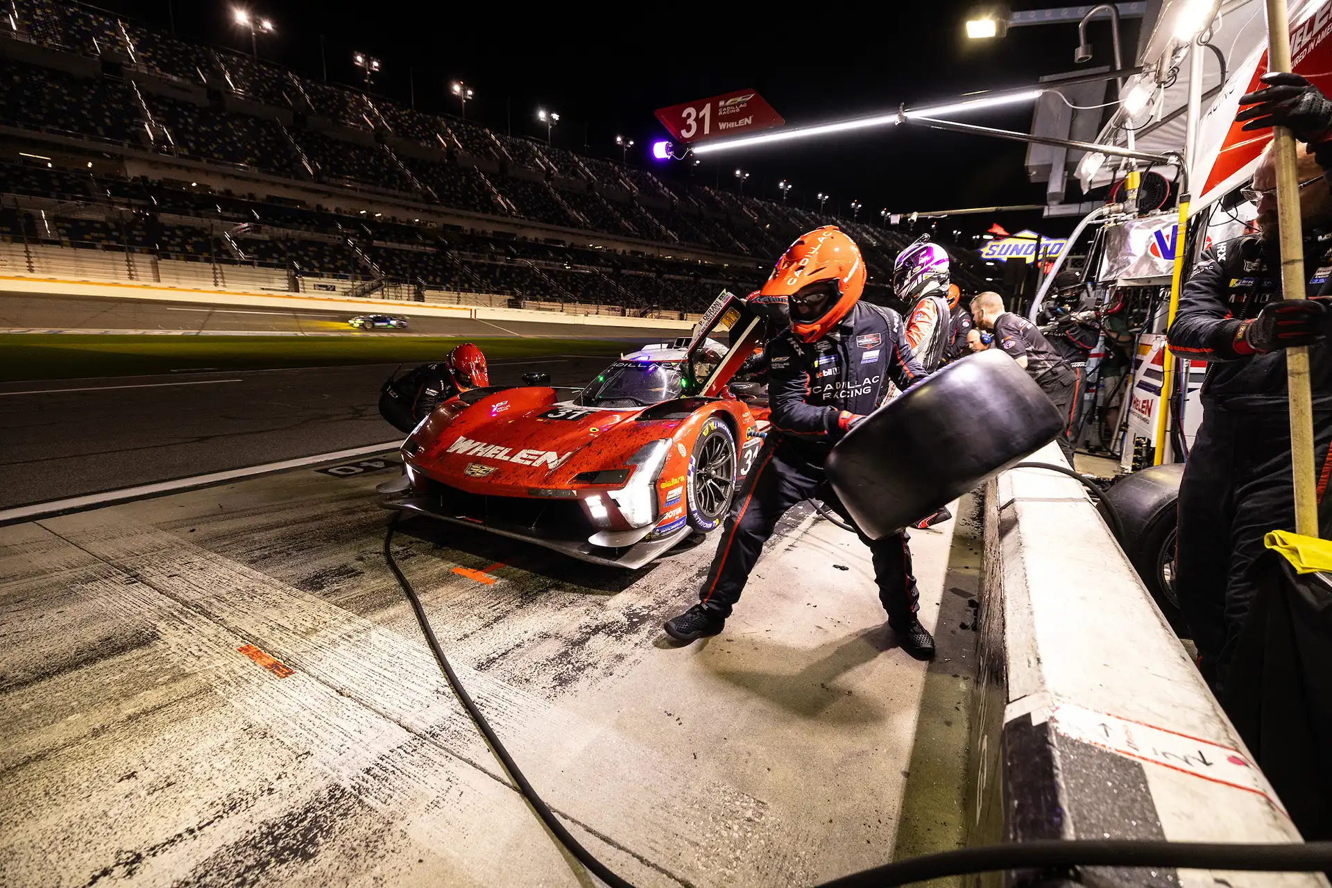 A red racecar making a pit stop.