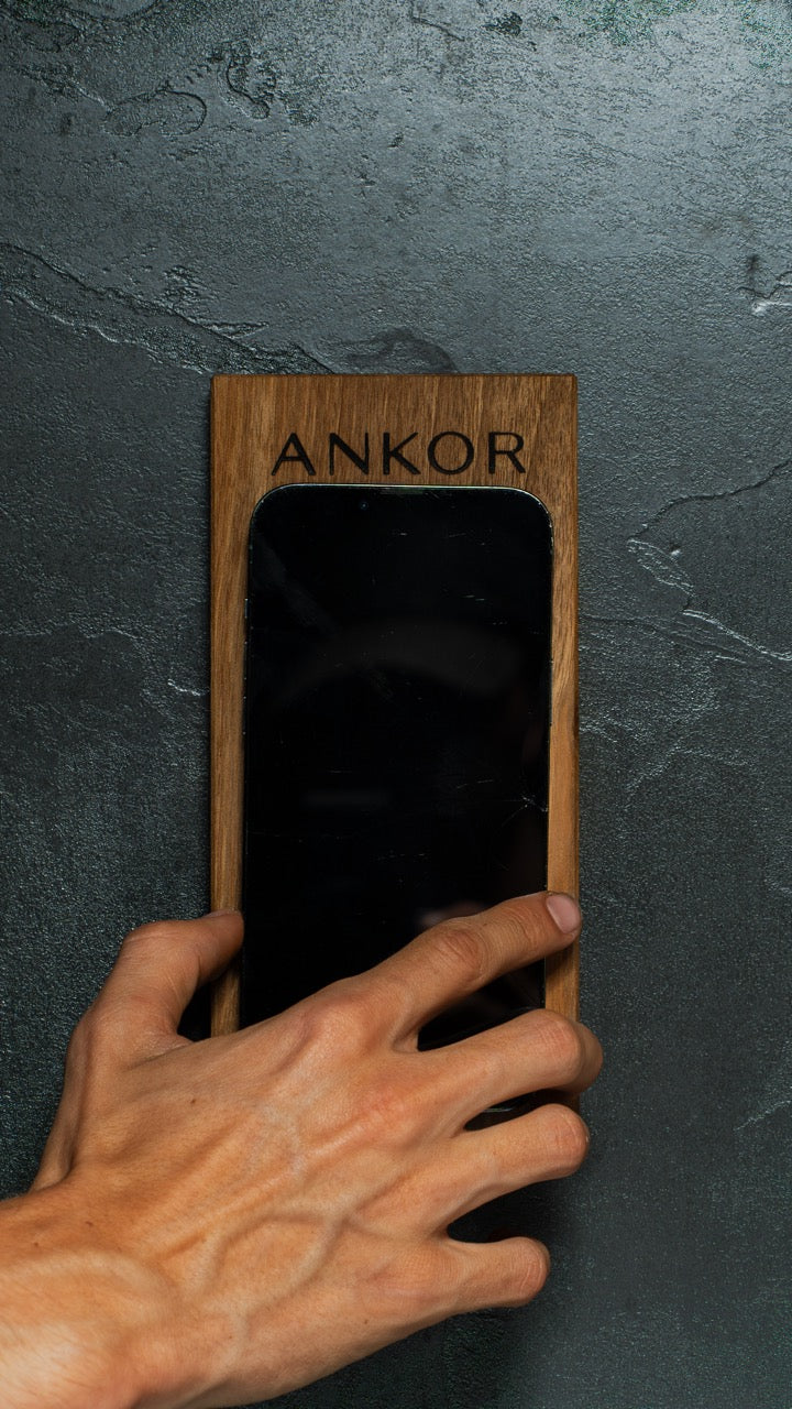 ANKOR natural oak dock mounted on wall with hand placing phone
