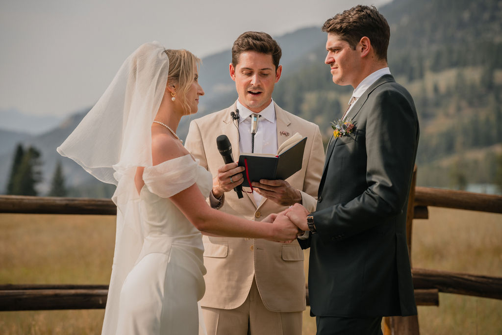 Couple exchanging vows with an officiant outdoors