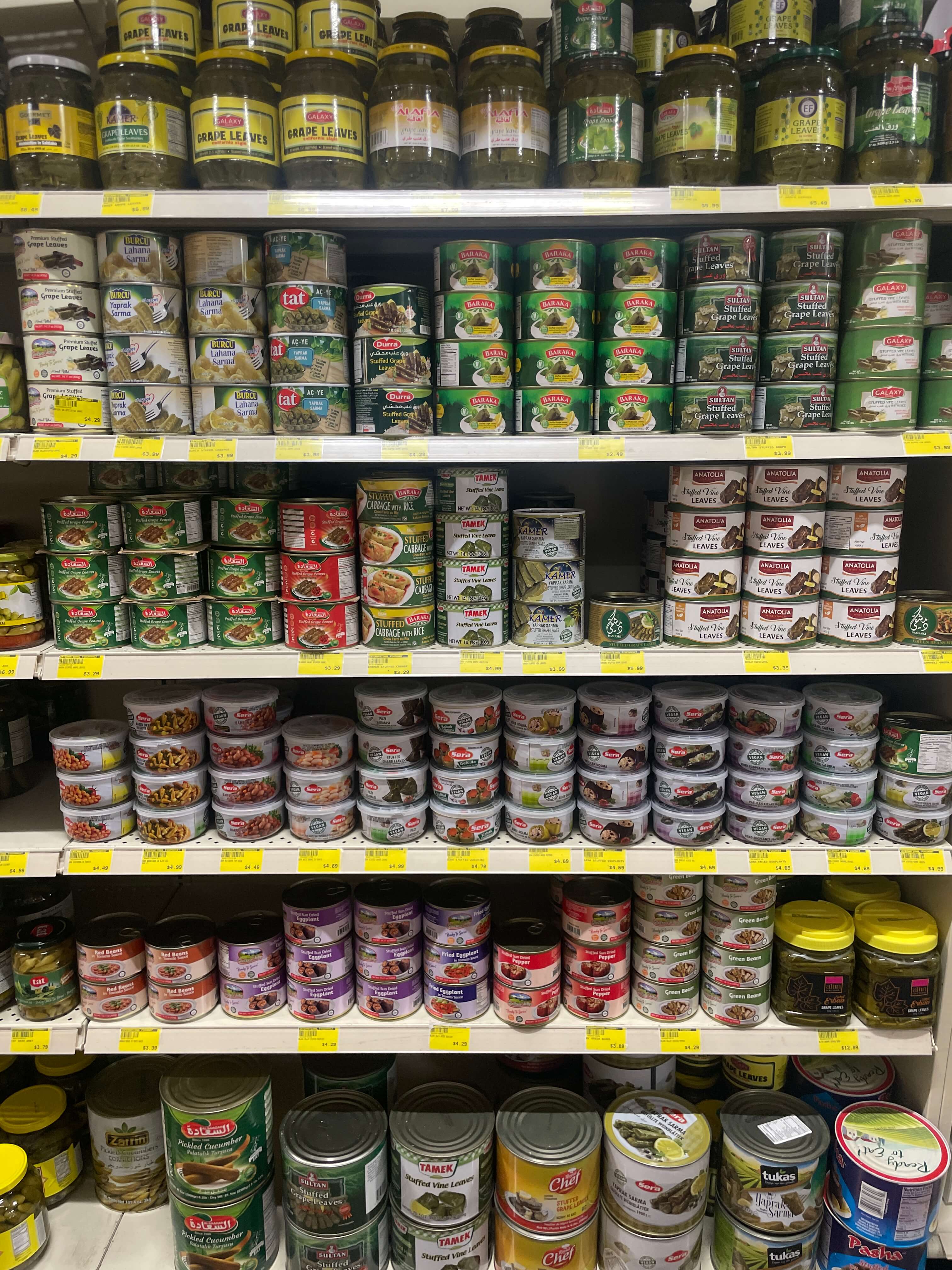 Canned goods including grape leaves, stuffed vegetables, and tuna at International Food Market Orlando.