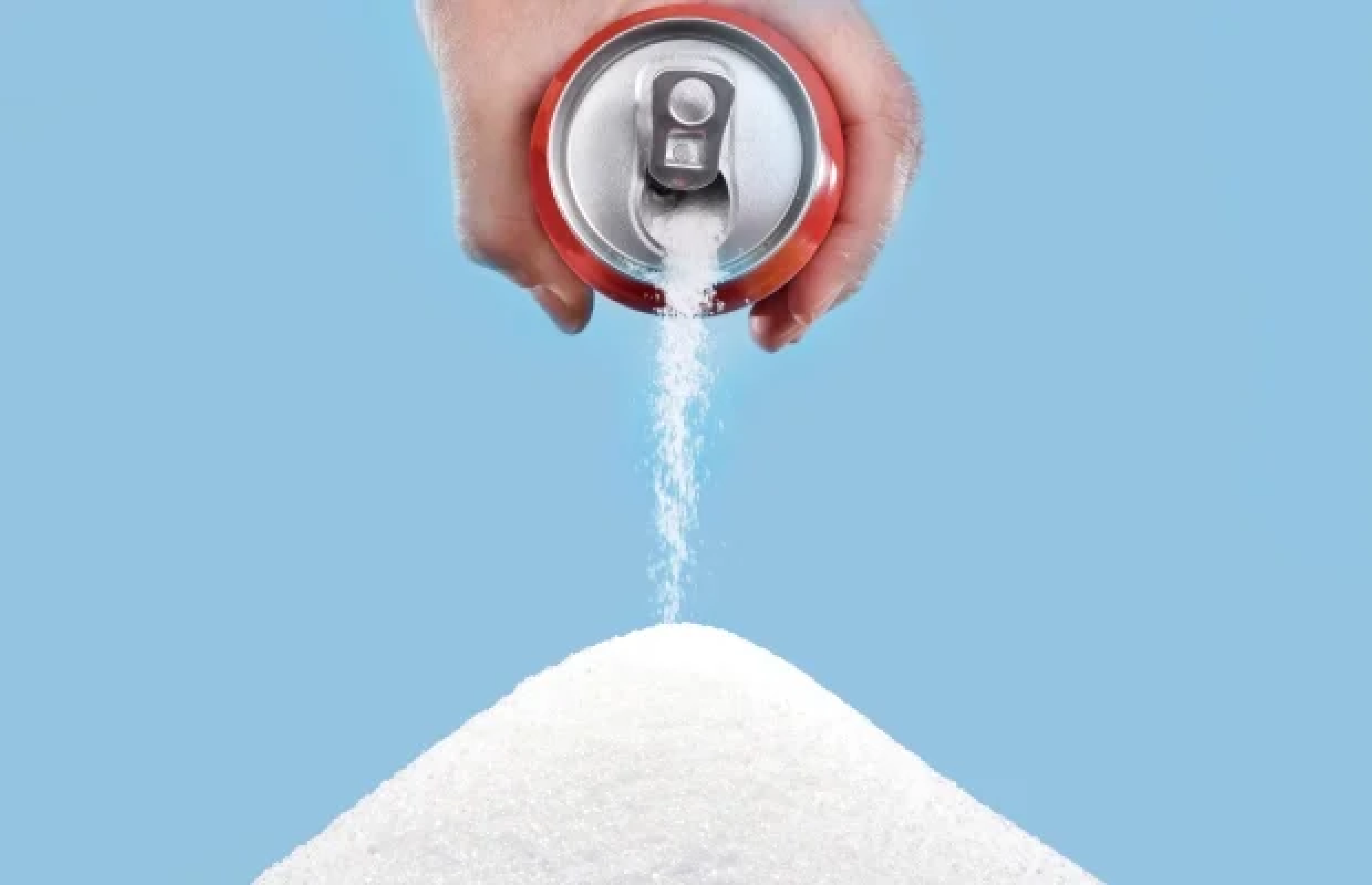 Hand pouring sugar from a soda can, representing the high sugar content in sugary beverages."