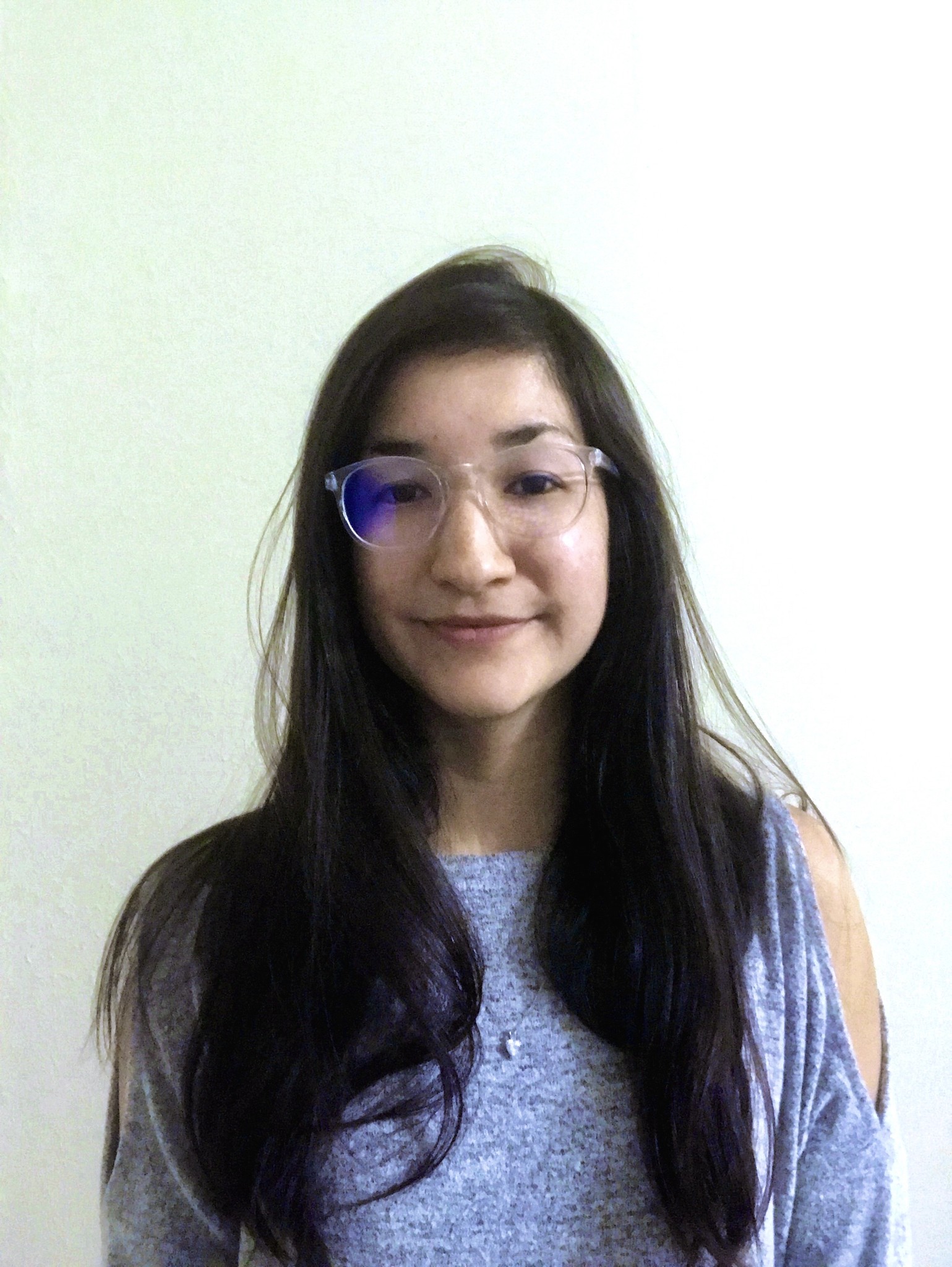 A photo of a woman wearing glasses looking at you