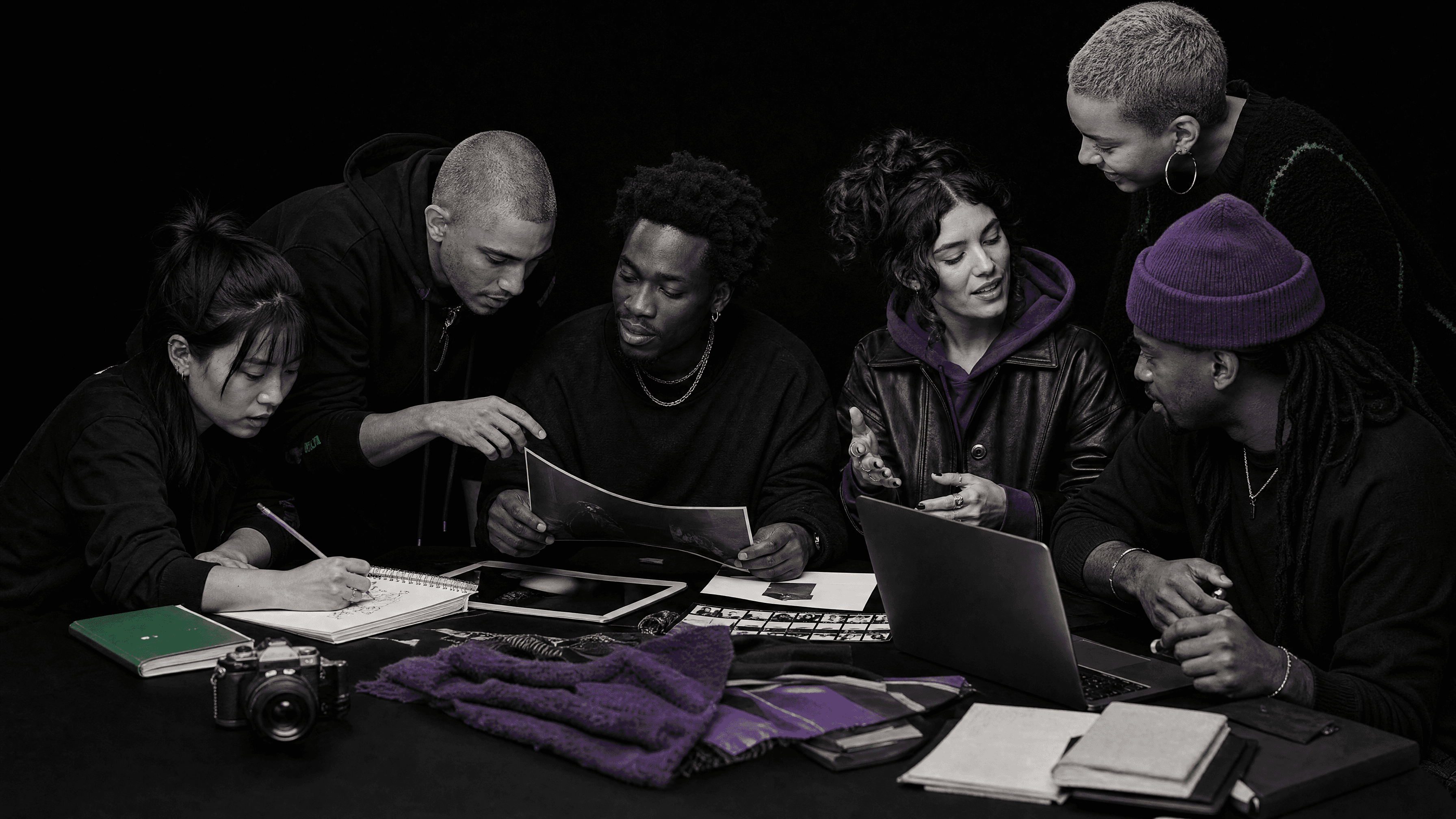 Adult creatives collaborating around a worktable during a candid Session Zone-inspired creative session.