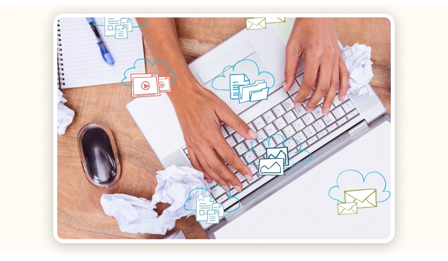 Laptop surrounded by crumpled papers