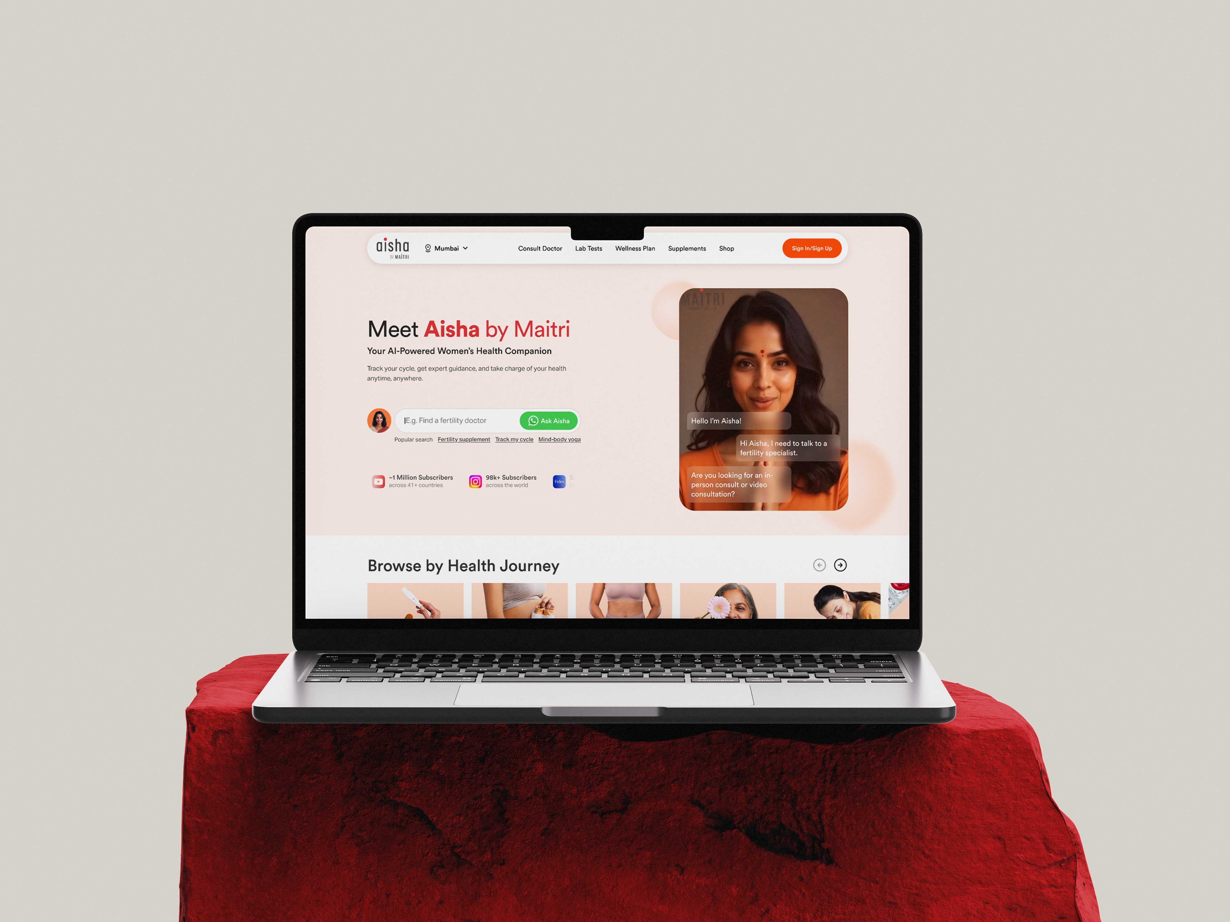 Aisha by Maitri AI health companion website displayed on laptop showing Meet Aisha landing page with health journey browsing interface and warm, approachable design