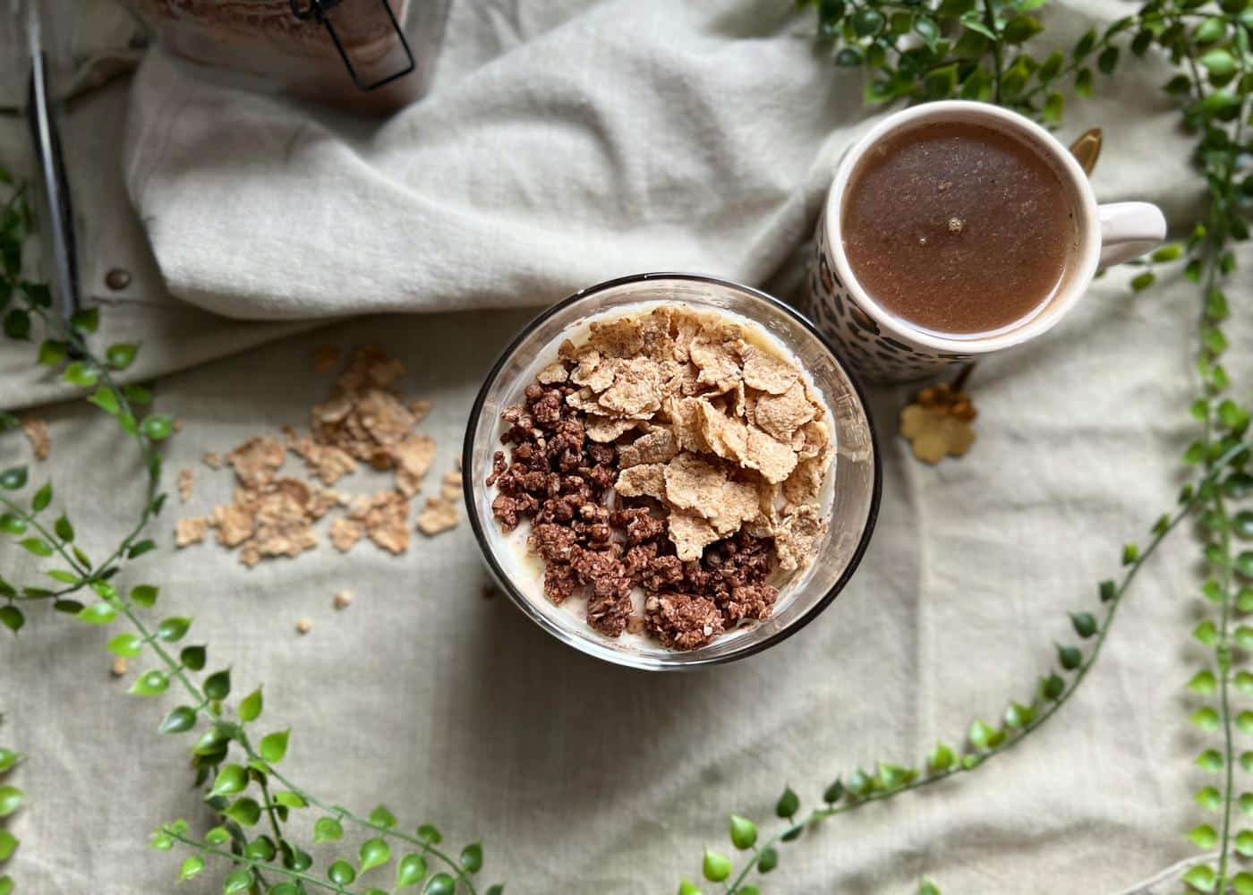 creal with nuts next to a cup of coffee on a gray tablecloth