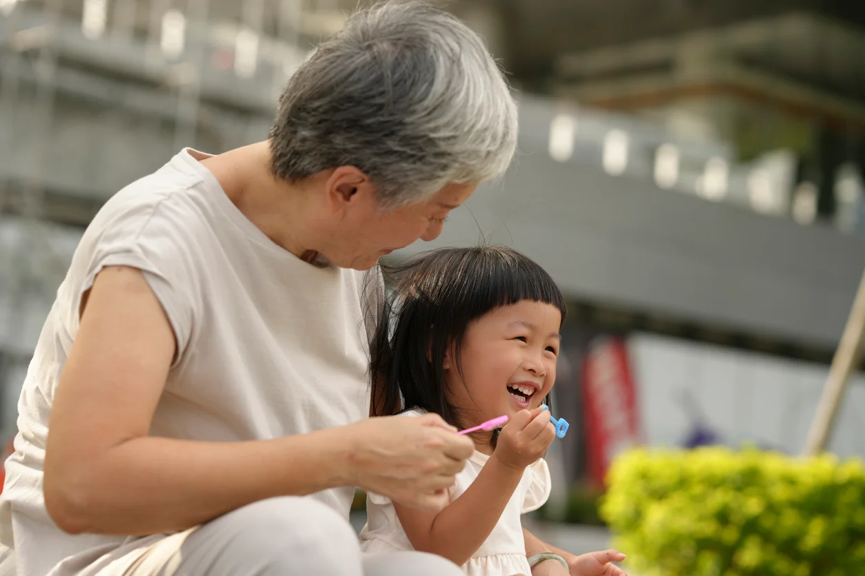 Confinement nanny smiling with child outdoors