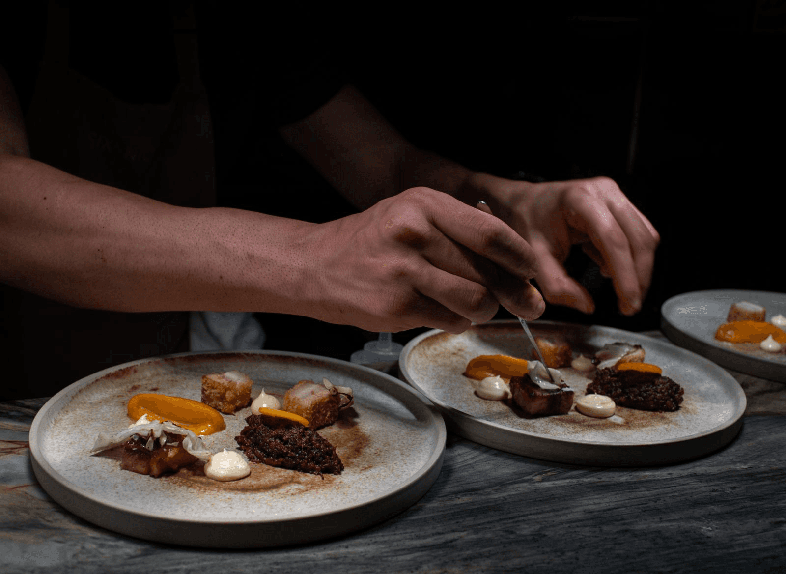 Desserts with whipped cream and nuts served on small plates.