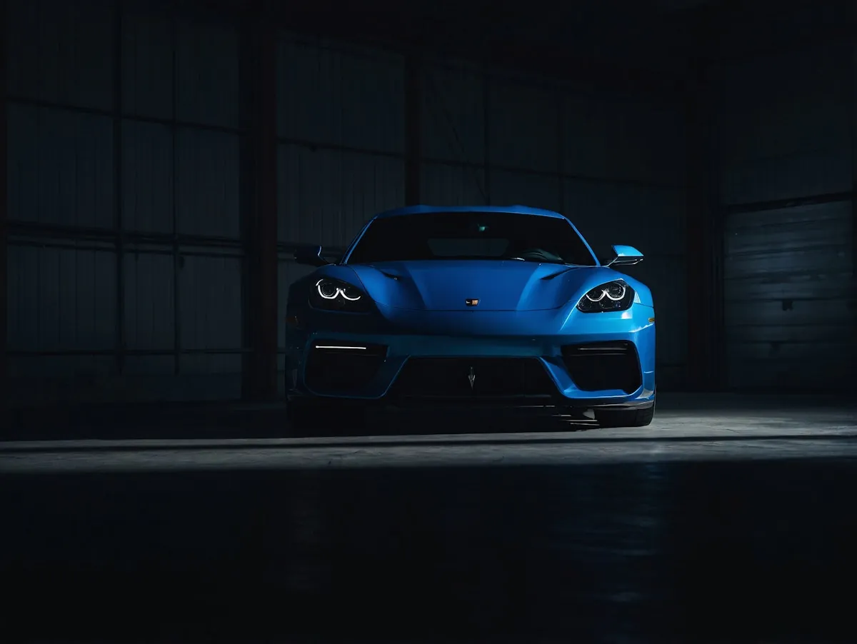 Blue sports car in a dark garage.
