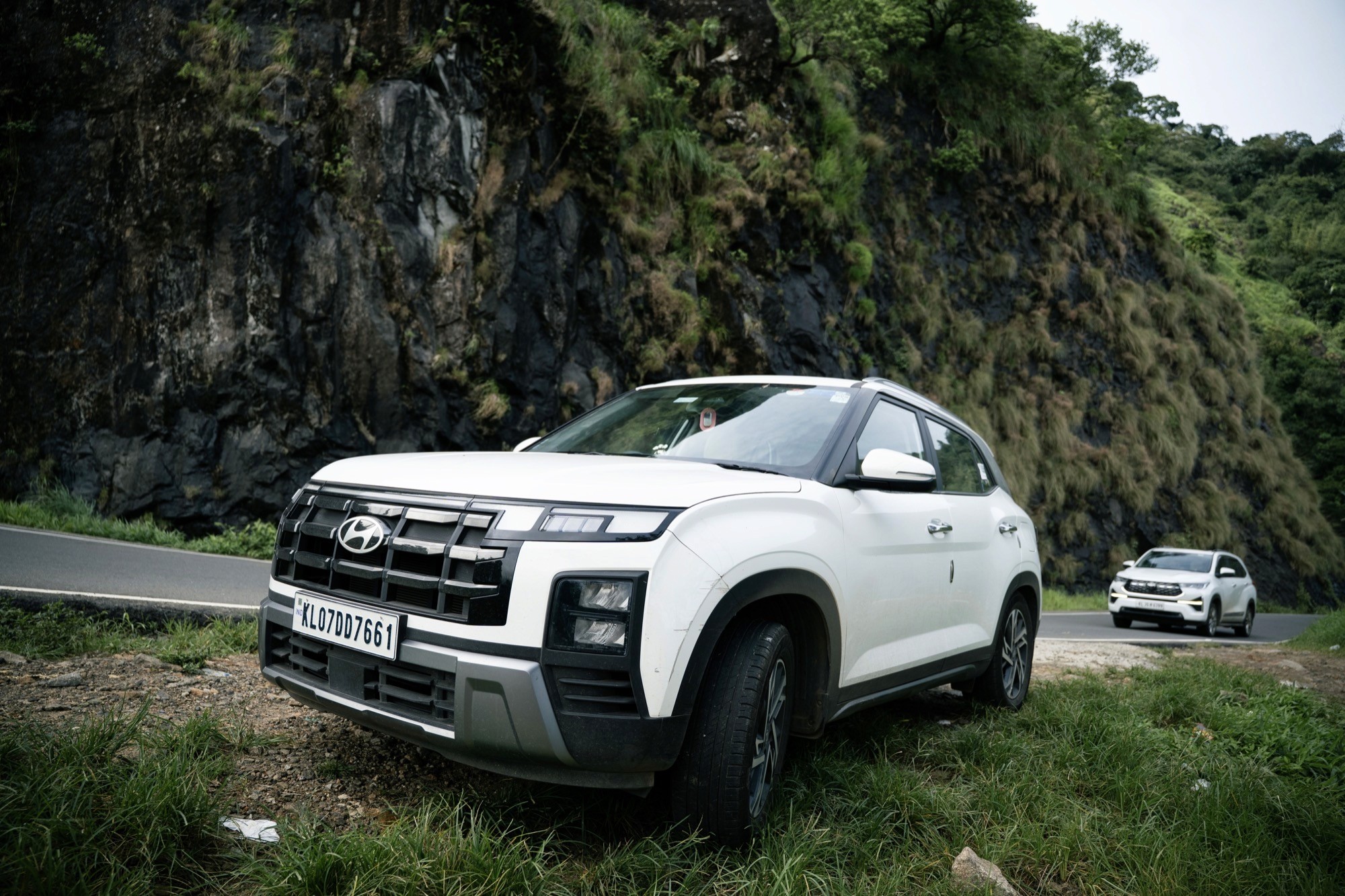 A car parked at the edge of the hill road