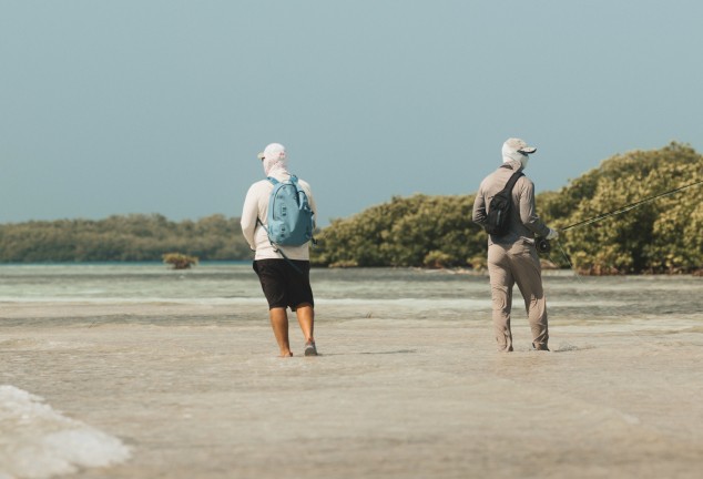 Fly fishing guide Marlon Leslie walking a shallow flat with a saltwater angler