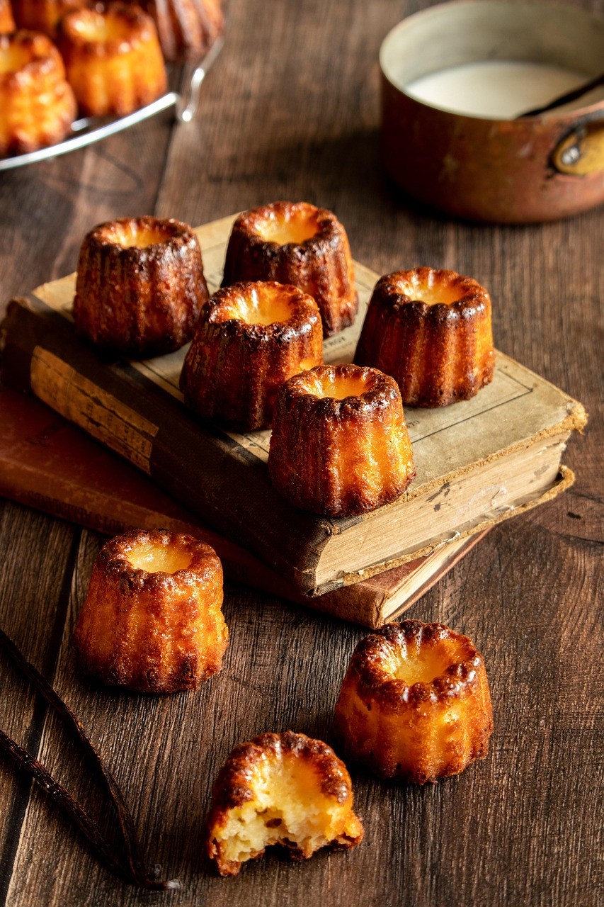 Golden-brown French cannelés with a crispy exterior and creamy vanilla center, freshly baked and ready to enjoy.