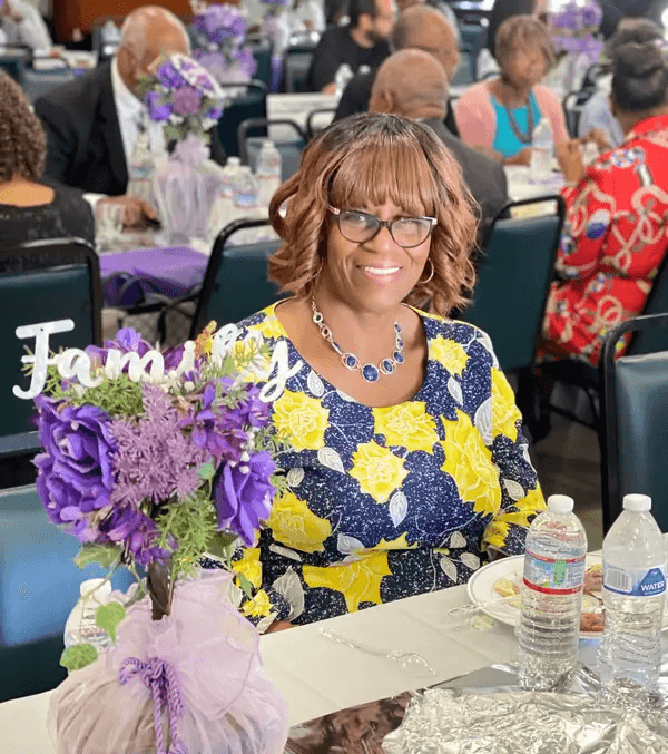 Church member holding flowers during a fellowship event at Peace Apostolic Church