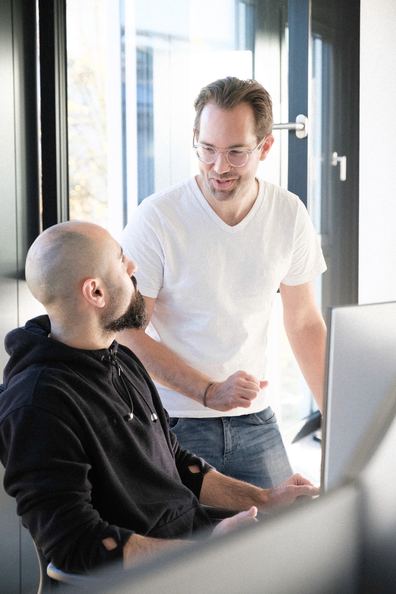 CEO Albert Schwarzmeier in intensiver Diskussion mit dem Head of Finance Amir Farsar, beide haben einen entspannten Gesichtsausdruck.