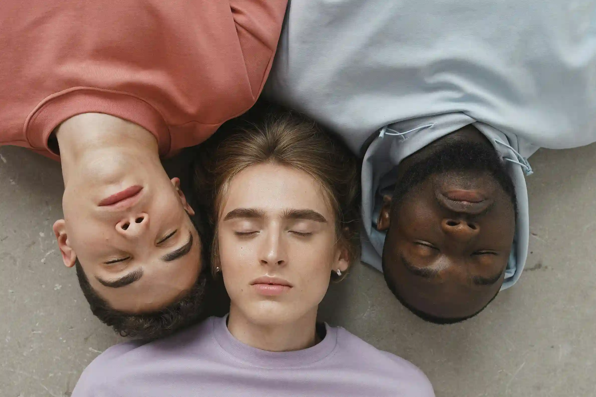Woman drinks fruit infused water from glass bottle in park.